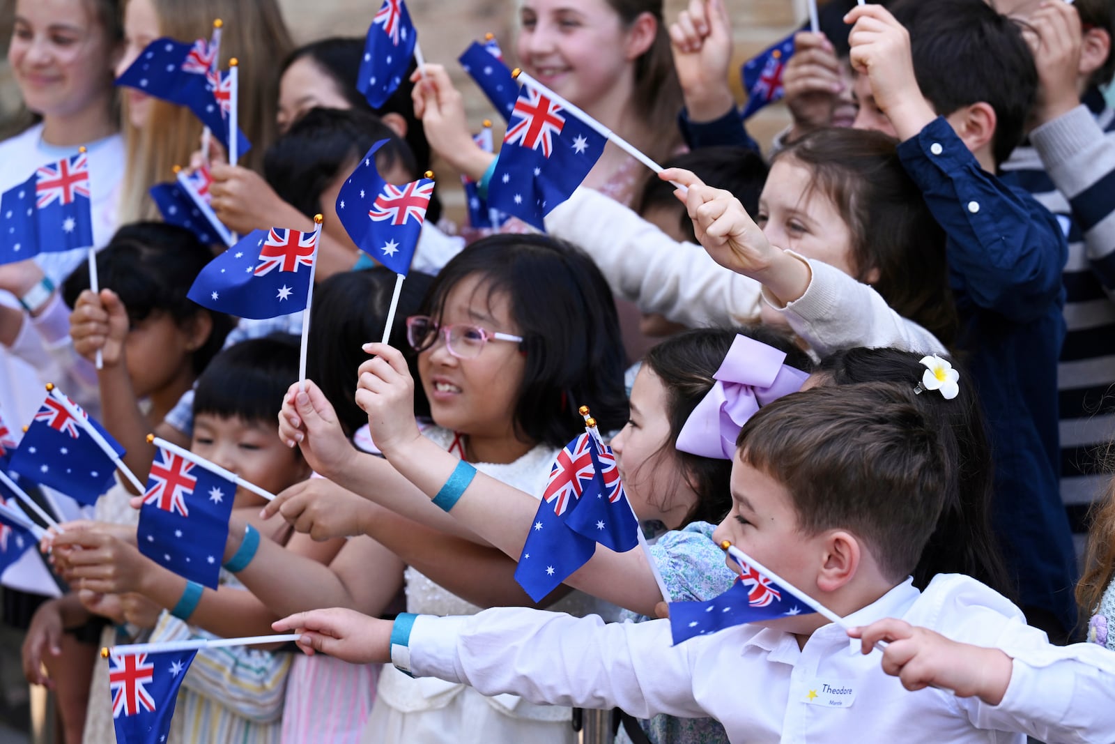 Children wave New Zealand flags as King Charles III and Queen Camilla visit St Thomas' Anglican Church in Sydney, Sunday, Oct. 20, 2024. (Dean Lewins/Pool Photo via AP)