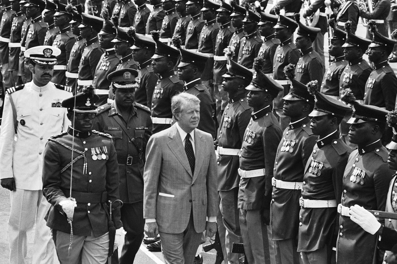 FILE - U.S. President Jimmy Carter reviews honor guards during arrival ceremonies at the Dodan Barracks in Lagos, Nigeria, April 1, 1978. (AP Photo, File)