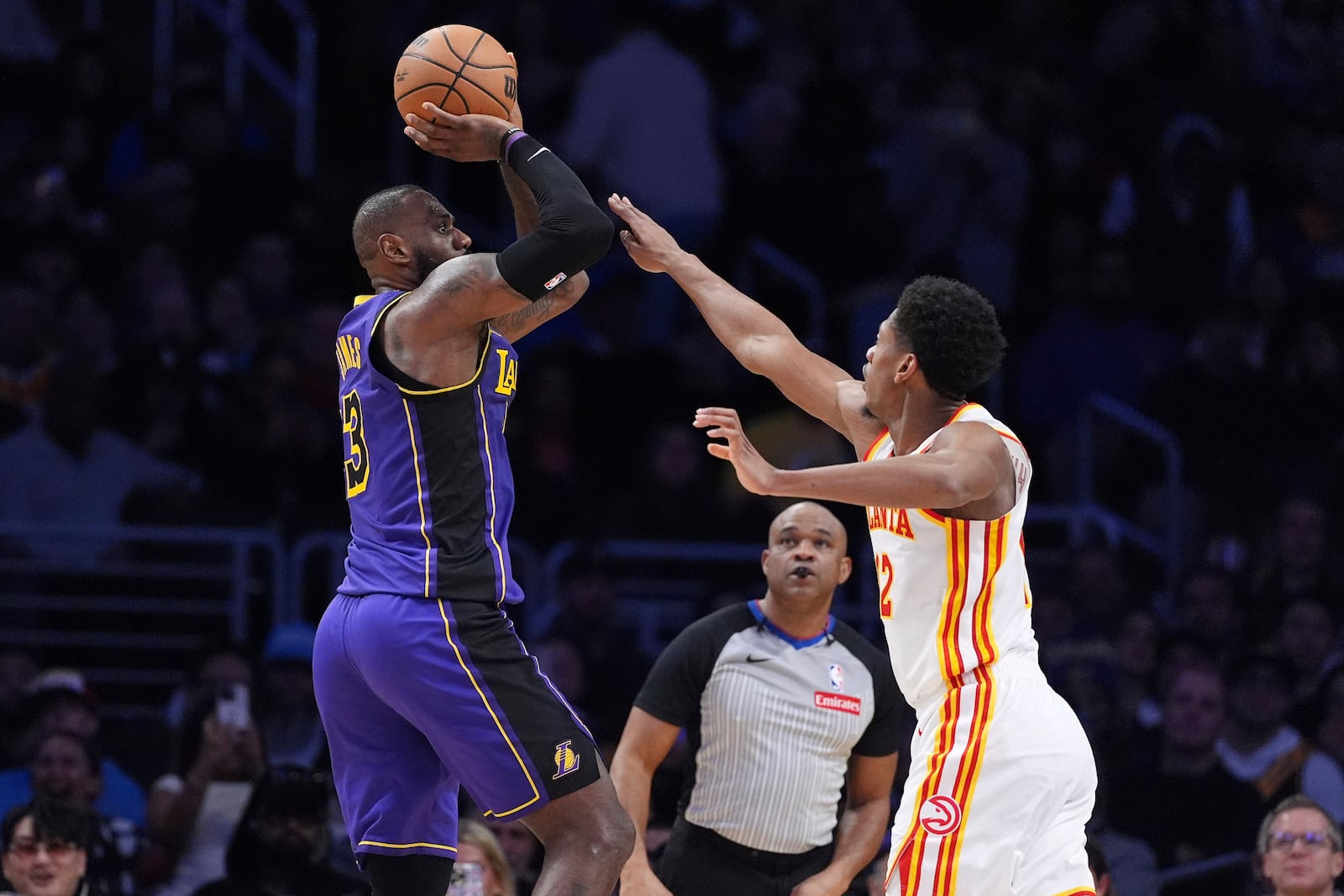 Los Angeles Lakers forward LeBron James, left, shoots as Atlanta Hawks forward De'Andre Hunter defends during the second half of an NBA basketball game, Friday, Jan. 3, 2025, in Los Angeles. (AP Photo/Mark J. Terrill)