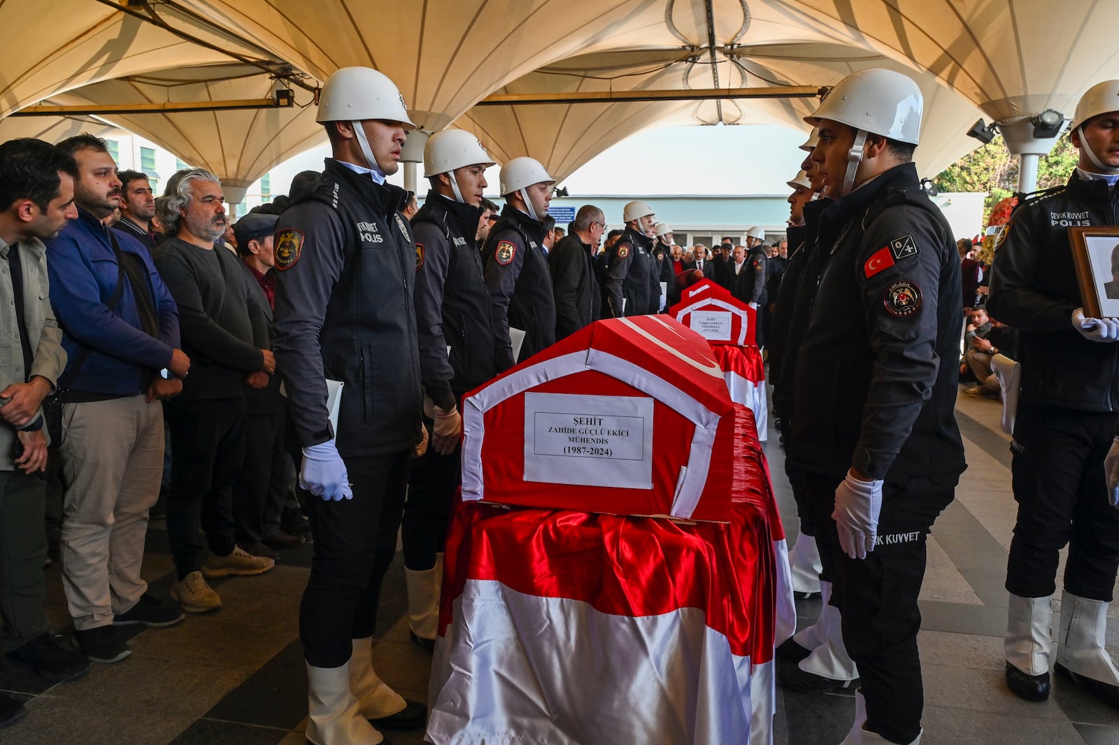 Turkish soldiers stand next to the coffins of Zahide Guglu Ekici, Hasan Huseyin Canbaz and Cengiz Coskun during their funeral at Karsiyaka mosque in Ankara, Thursday, Oct. 24, 2024, a day after they were killed during an attack by PKK members at the Turkish aerospace and defense company TUSAS on Wednesday. (AP Photo/Ali Unal)