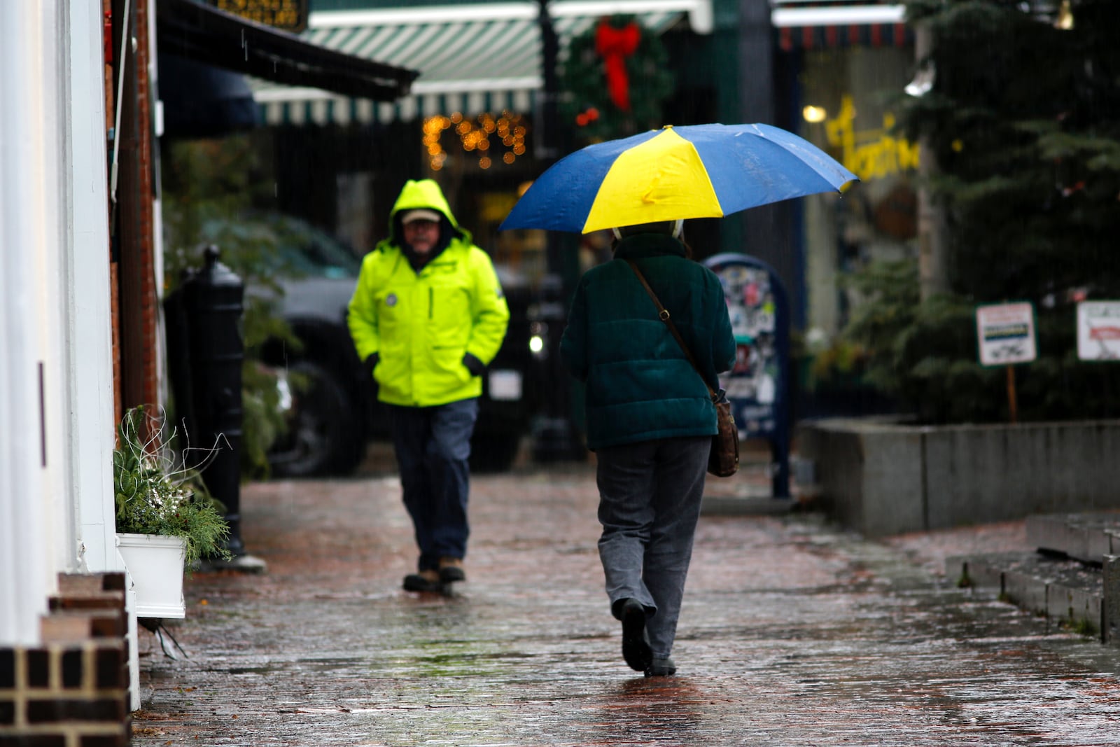 People walk through the rain as a storm system and possible "bomb cyclone" hit the U.S. East Coast, Wednesday, Dec. 11, 2024 in Portsmouth, N.H. (AP Photo/Caleb Jones)