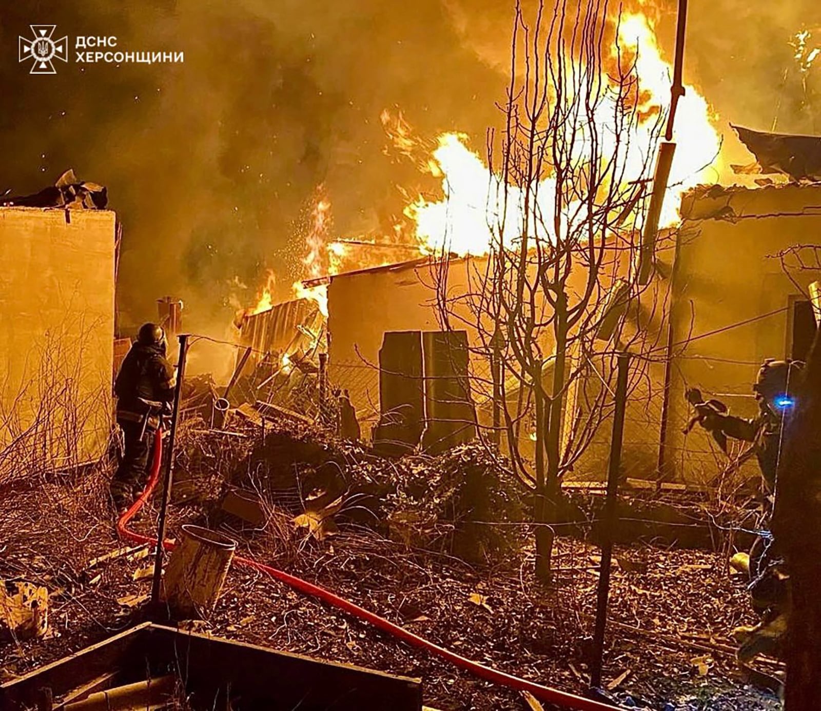 In this photo provided by the Ukrainian Emergency Service, firefighters put out the fire at the private houses following a Russian guided air bombs attack in Kherson, Ukraine, Saturday, March 15, 2025. (Ukrainian Emergency Service via AP)