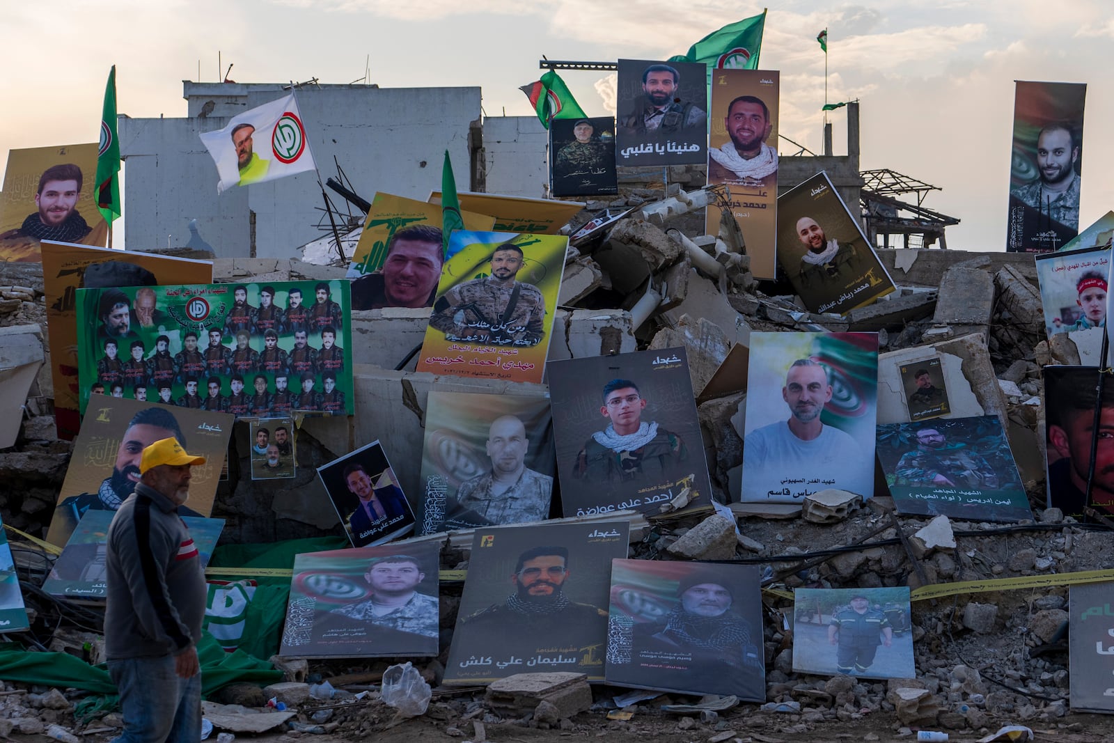 A Lebanese man walks past portraits of Hezbollah and Amal Movement fighters in Khiam, southern Lebanon, Monday, Feb. 17, 2025, who were killed during the last war between Israel and Hezbollah. (AP Photo/Hassan Ammar)