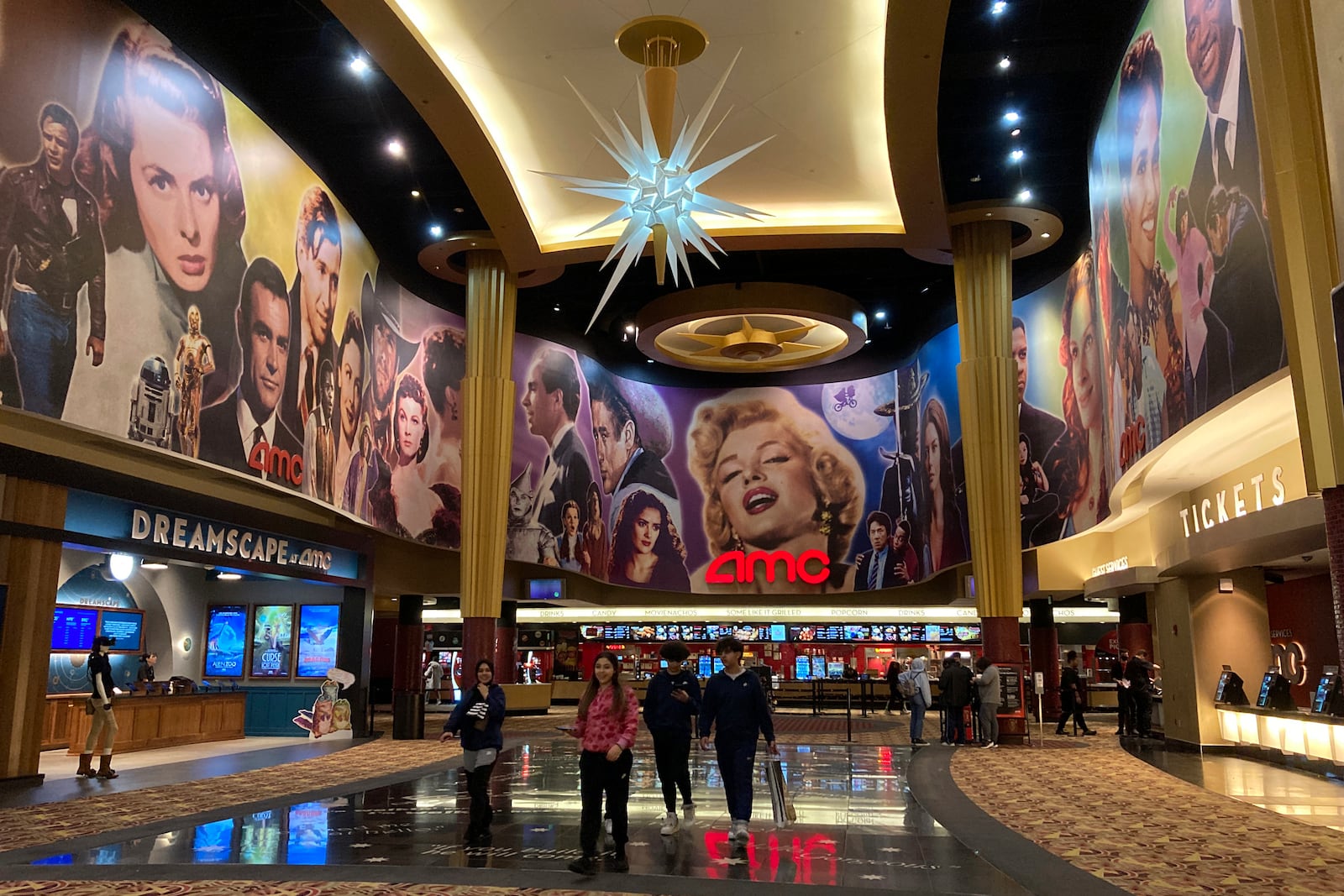 FILE - People walk in an AMC Theater in Paramus, New Jersey, on Monday, March 13, 2023. (AP Photo/Ted Shaffrey, File)