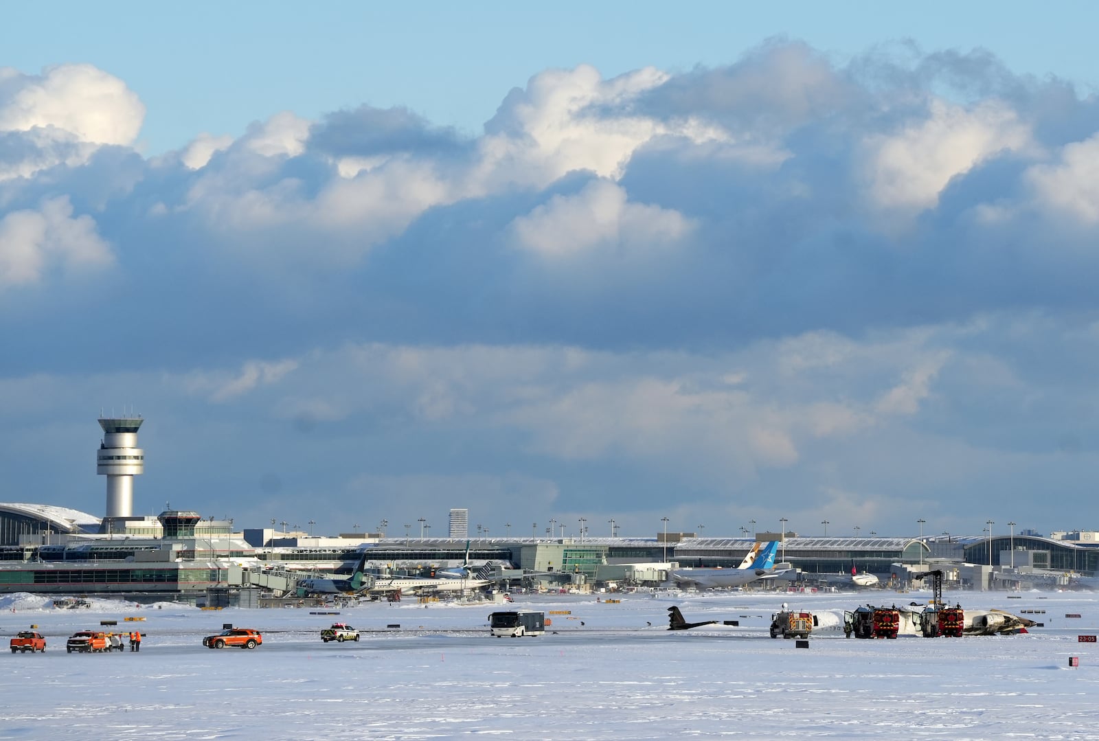 Crews work around an upside down Delta Air Lines plane, which was heading from Minneapolis to Toronto when it crashed on the runway at Pearson International Airport, in Toronto, Monday, Feb. 17, 2025. (Teresa Barbieri/The Canadian Press via AP)