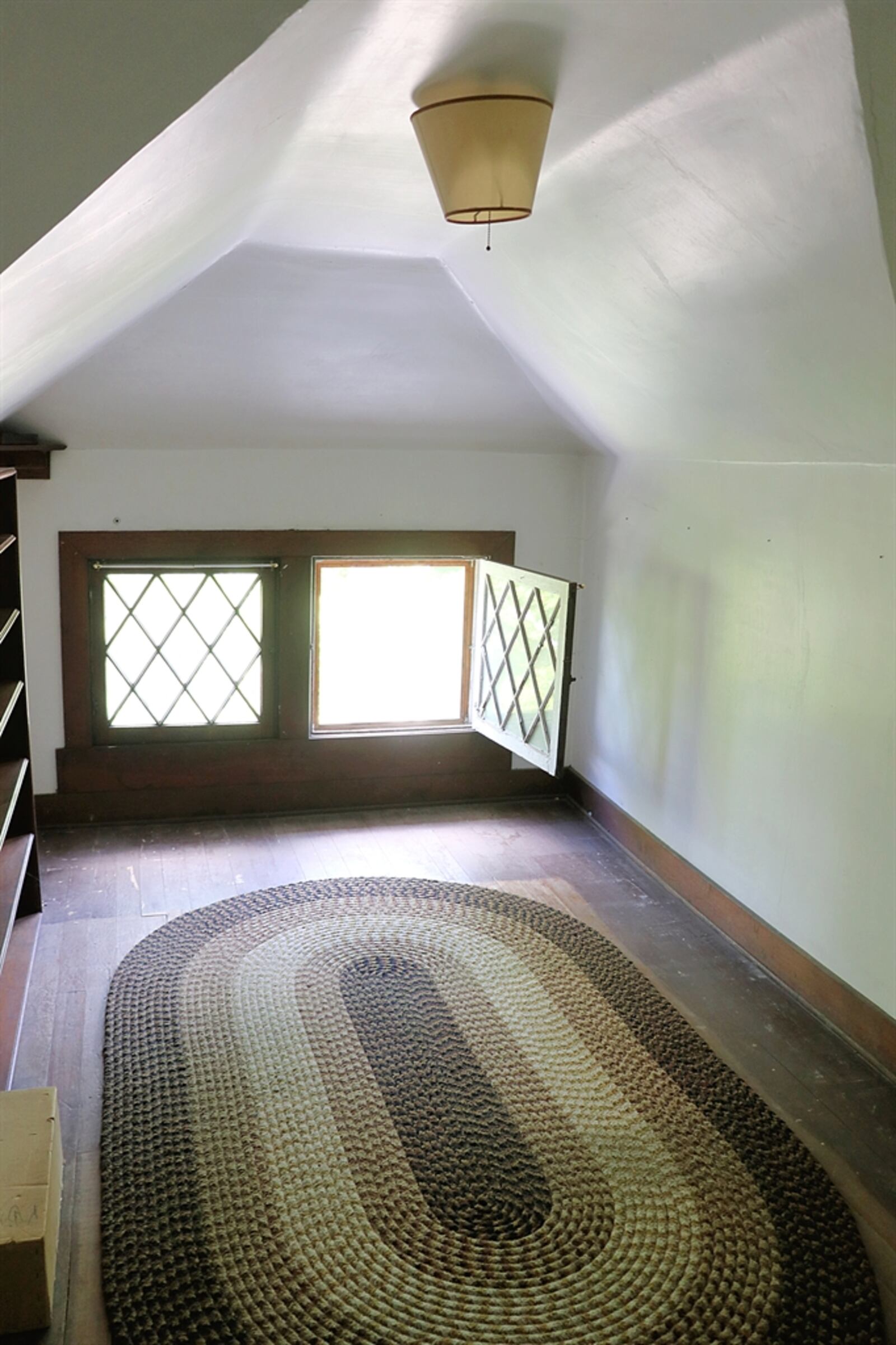 This room has hardwood flooring and an angled ceiling with floor-level windows. 