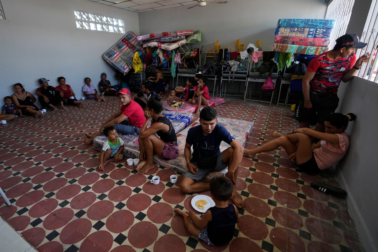 People displaced by violence in the Catatumbo region, where rebels of the National Liberation Army (ELN) have been clashing with former members of the Revolutionary Armed Forces of Colombia (FARC), take shelter at a school in Tibu, Colombia, Monday, Jan. 20, 2025. (AP Photo/Fernando Vergara)