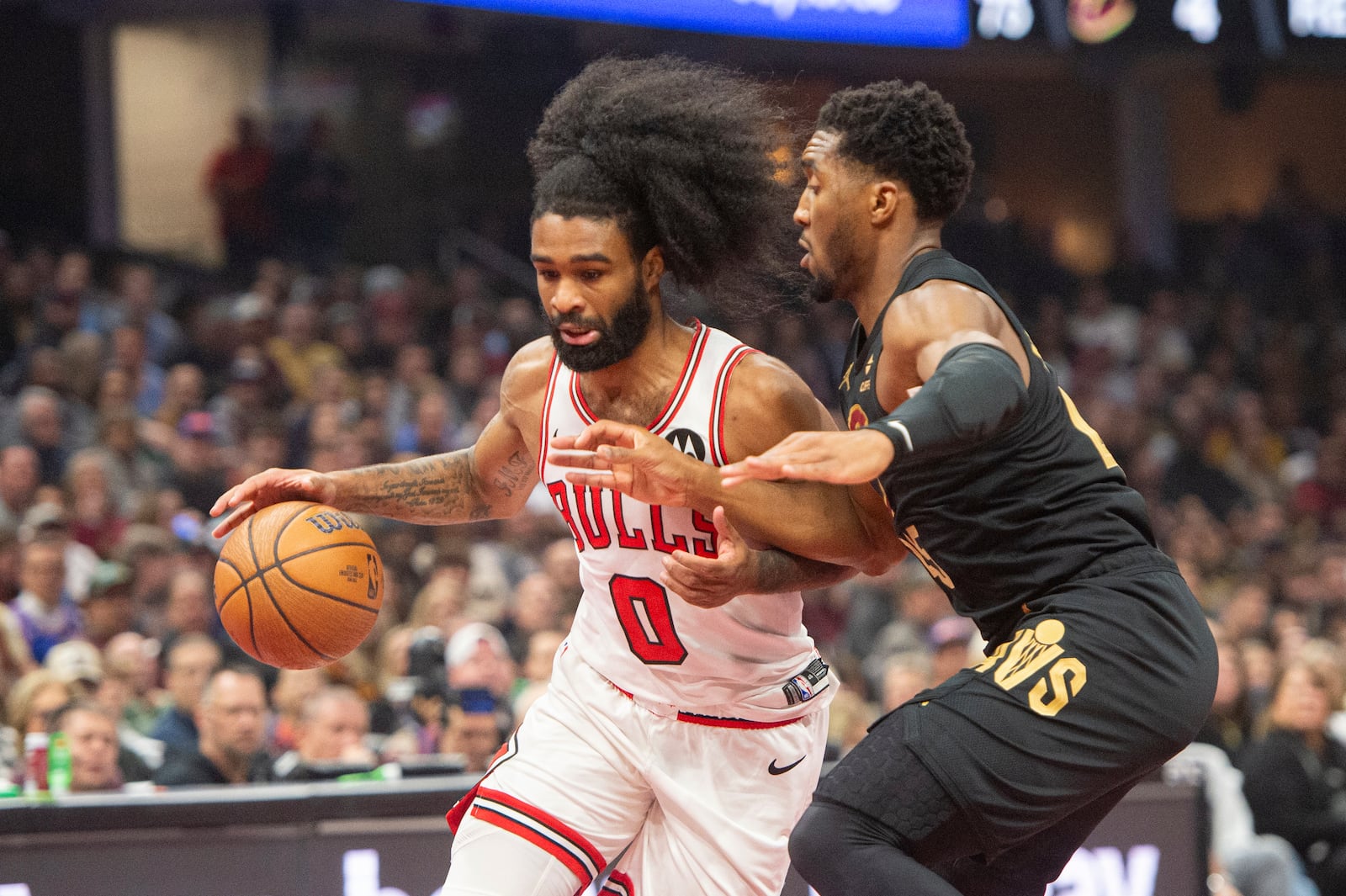 Chicago Bulls' Coby White (0) drives against Cleveland Cavaliers' Donovan Mitchell, right, during the first half of an Emirates NBA Cup basketball game in Cleveland, Friday, Nov 15, 2024. (AP Photo/Phil Long)