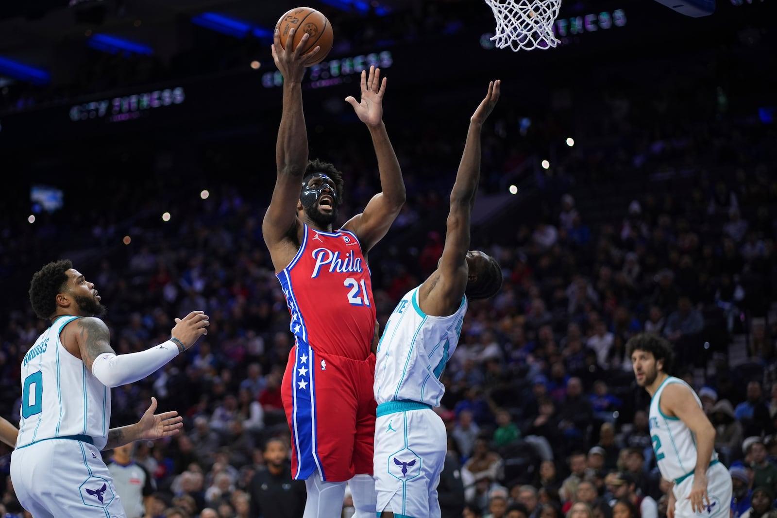 Philadelphia 76ers' Joel Embiid, left, goes up for a shot against Charlotte Hornets' Moussa Diabate during the second half of an NBA basketball game, Friday, Dec. 20, 2024, in Philadelphia. (AP Photo/Matt Slocum)