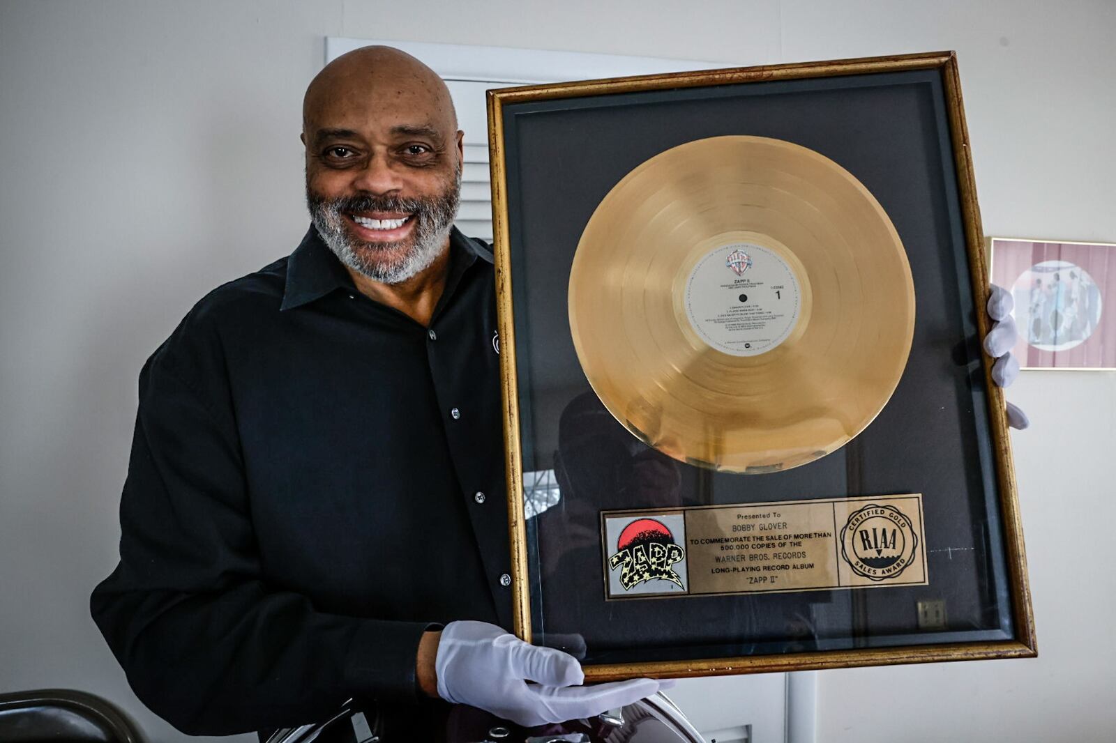 David R. Webb Sr. founder and CEO of the funk music hall of fame and exhibition center holds a Zapp gold record. Webb plans to move the funk collection to the old Sears building on Salem Ave. JIM NOELEKR/STAFF