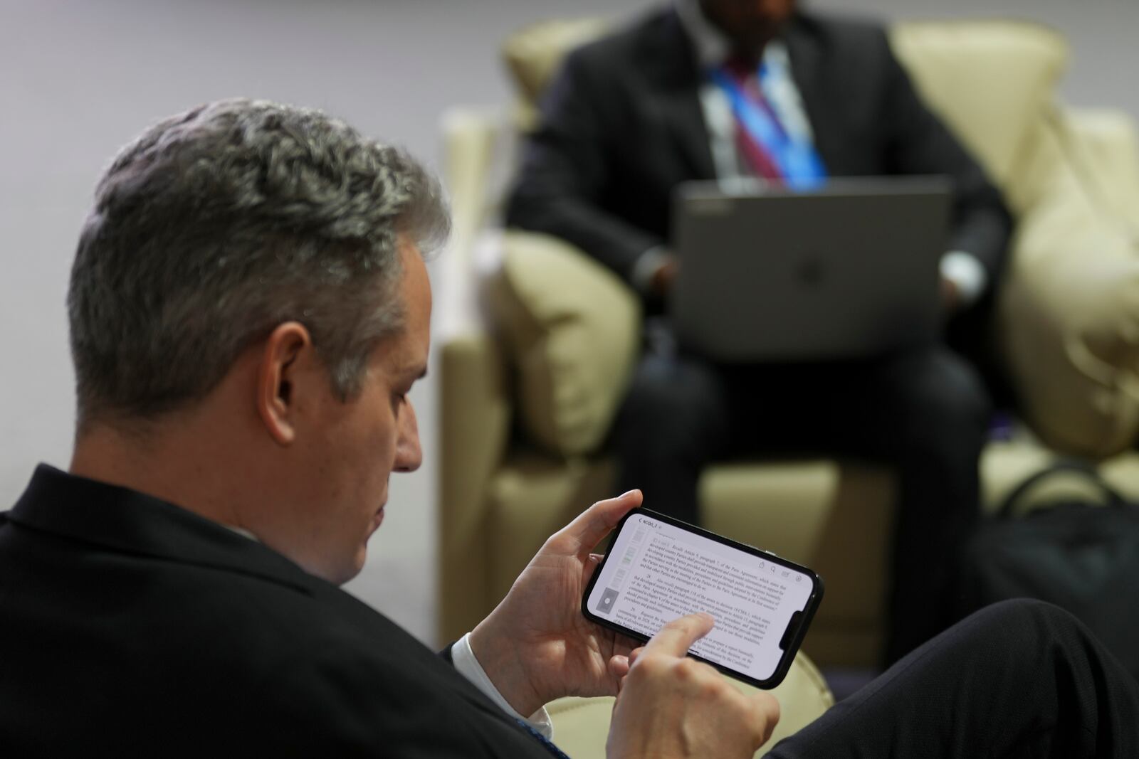 A person reads a draft of a proposed deal for curbing climate change during the COP29 U.N. Climate Summit, Friday, Nov. 22, 2024, in Baku, Azerbaijan. (AP Photo/Peter Dejong)