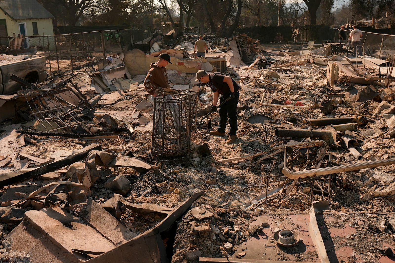 Residents dig through the rubble left behind by the Eaton Fire Friday, Jan. 10, 2025 in Altadena, Calif. (AP Photo/Jae C. Hong)