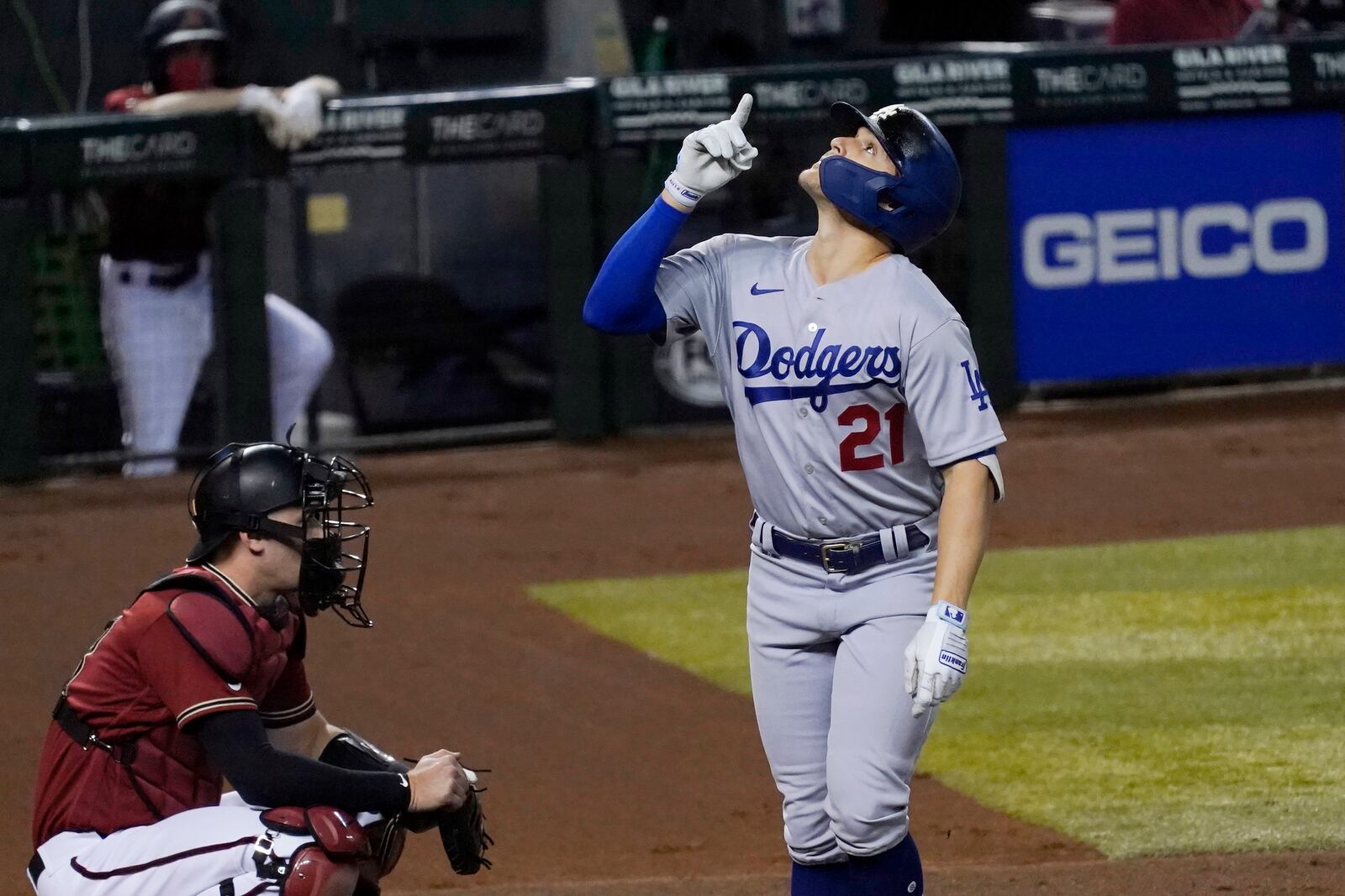 Los Angeles Dodgers' Enrique Hernandez, right, wearing Pittsburgh Pirates Hall of Fame player Roberto Clemente's No. 21 on Roberto Clemente Day, celebrates his home run as he pauses near Arizona Diamondbacks catcher Carson Kelly at home plate during the second inning of a baseball game Wednesday, Sept. 9, 2020, in Phoenix. (AP Photo/Ross D. Franklin)