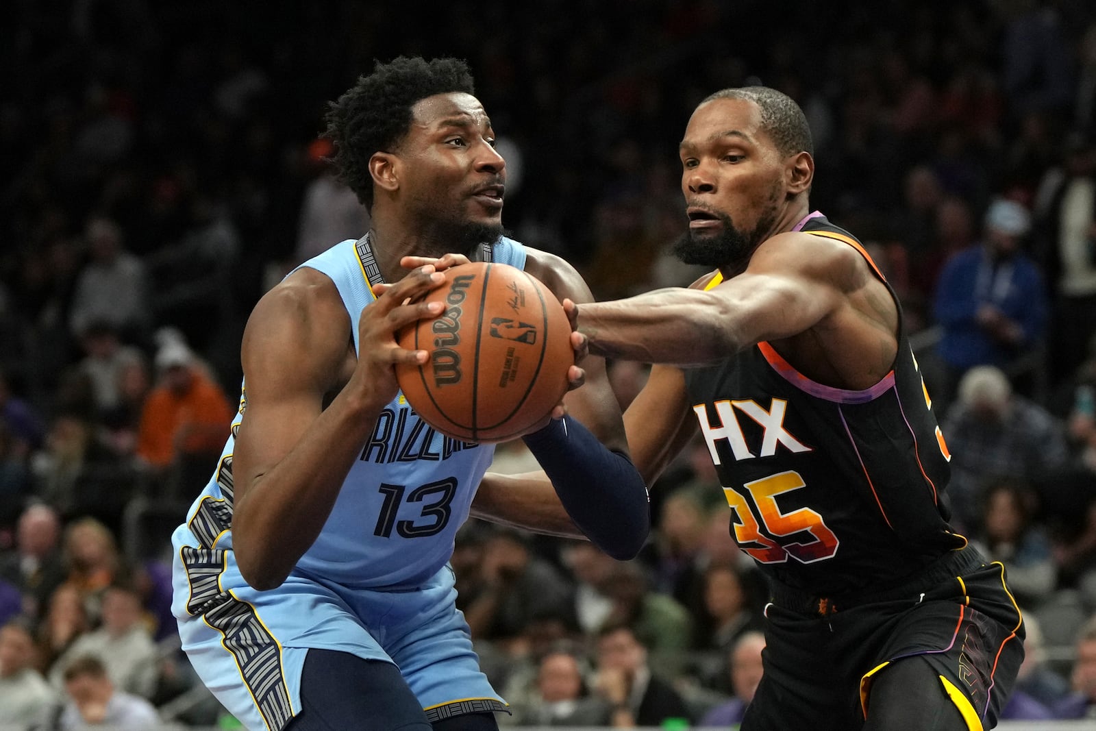 Memphis Grizzlies forward Jaren Jackson Jr. (13) drives against Phoenix Suns forward Kevin Durant during the second half of an NBA basketball game, Tuesday, Feb. 11, 2025, in Phoenix. (AP Photo/Rick Scuteri)