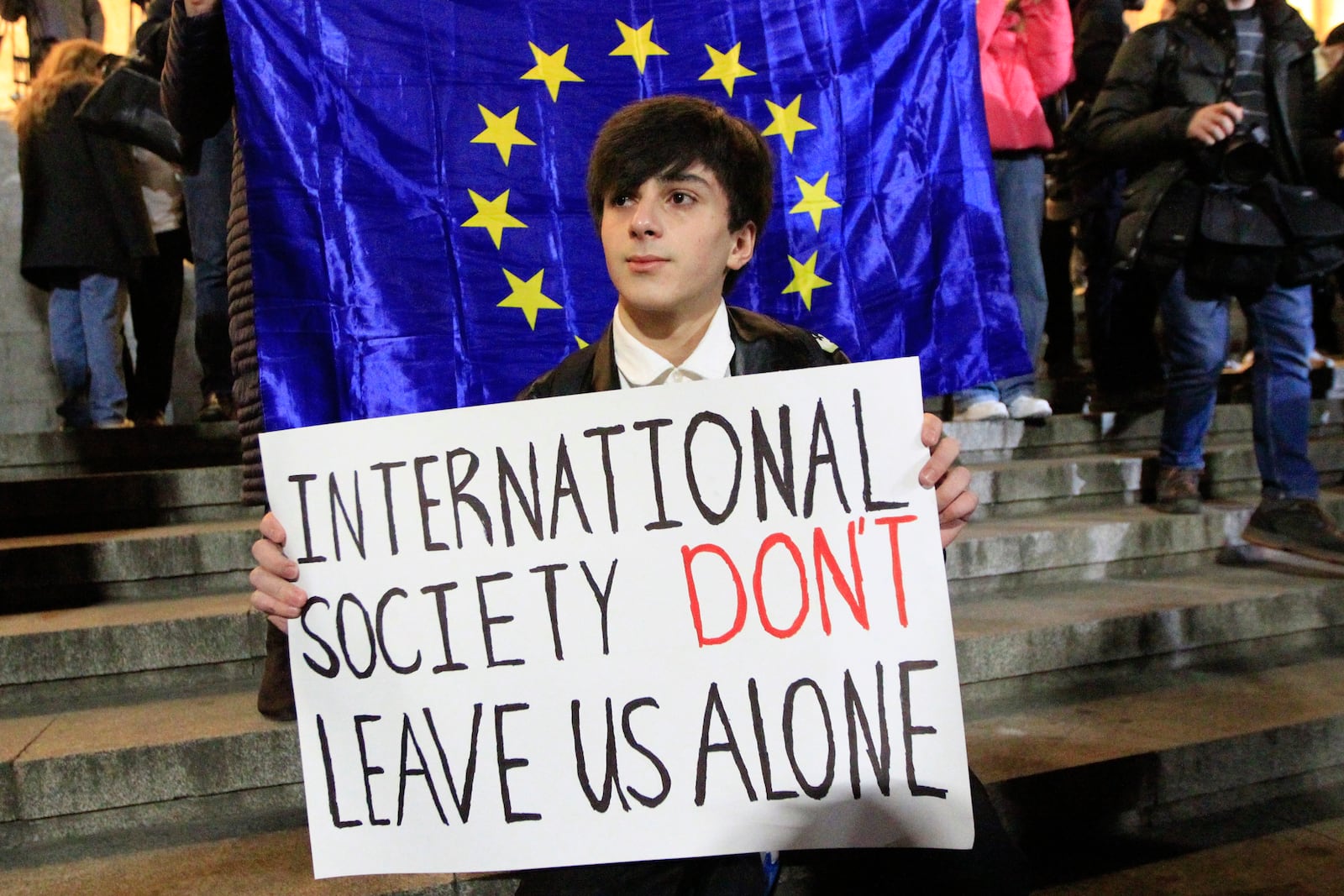 A man holds a poster during an opposition protest against the results of the parliamentary election in Tbilisi, Georgia, Monday, Oct. 28, 2024. (AP Photo/Shakh Aivazov)