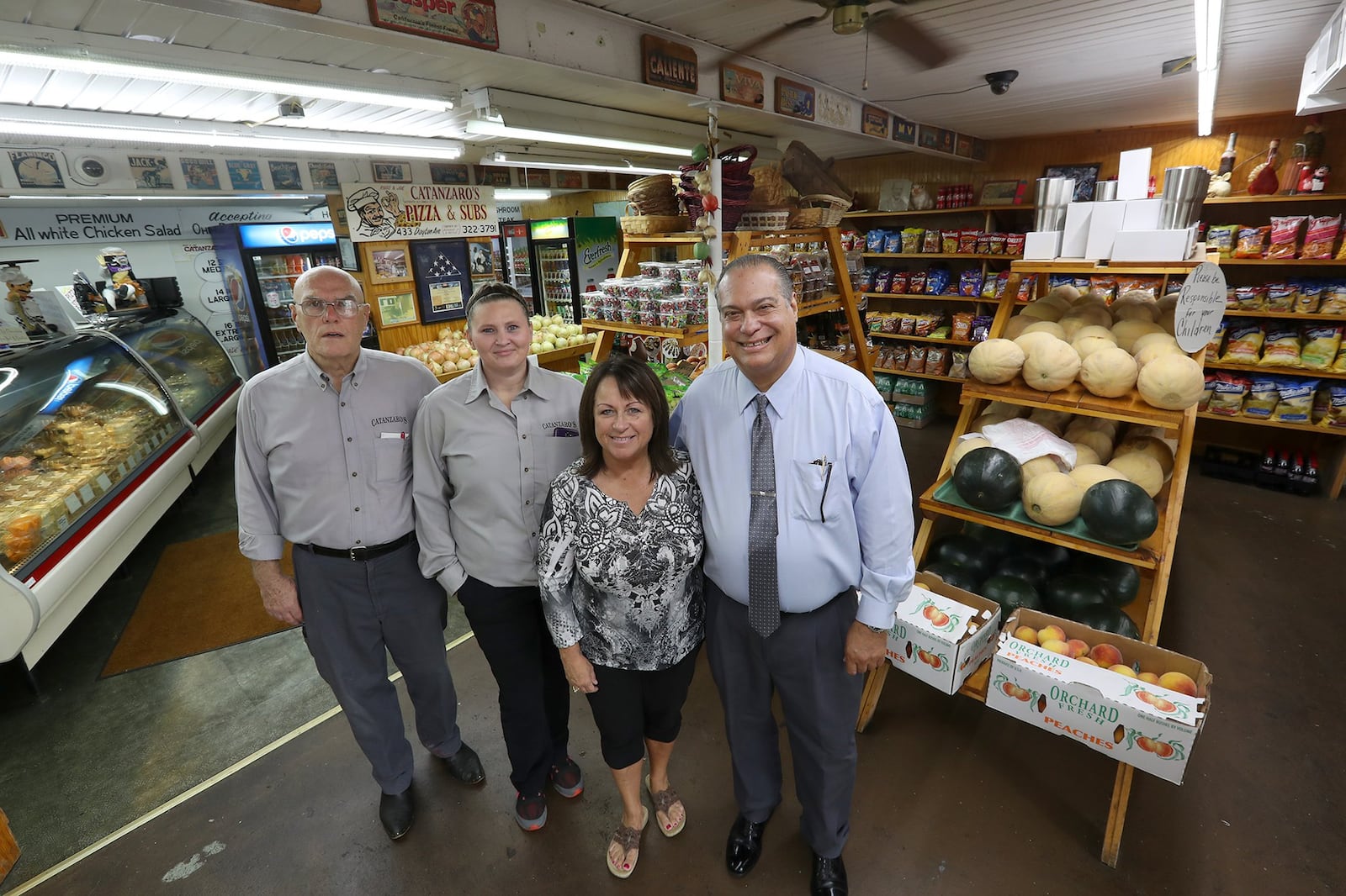 Joe Catanzaro, right, and his wife, Linda, pose for a picture with staff members Don Oder and Jennie Lanum in the store. BILL LACKEY/STAFF