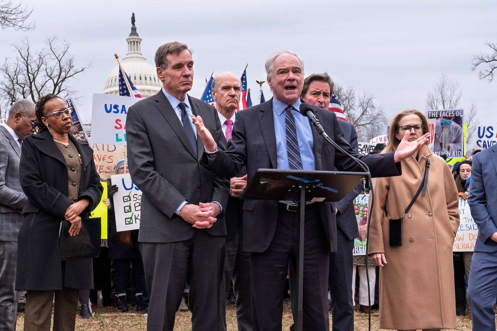 Demonstrators and lawmakers, including Sen. Mark Warner, D-Va., left, and Sen. Tim Kaine, D-Va., rally against President Donald Trump and his ally Elon Musk as they disrupt the federal government, including dismantling the U.S. Agency for International Development, which administers foreign aid approved by Congress, on Capitol Hill in Washington, Wednesday, Feb. 5, 2025. (AP Photo/J. Scott Applewhite)