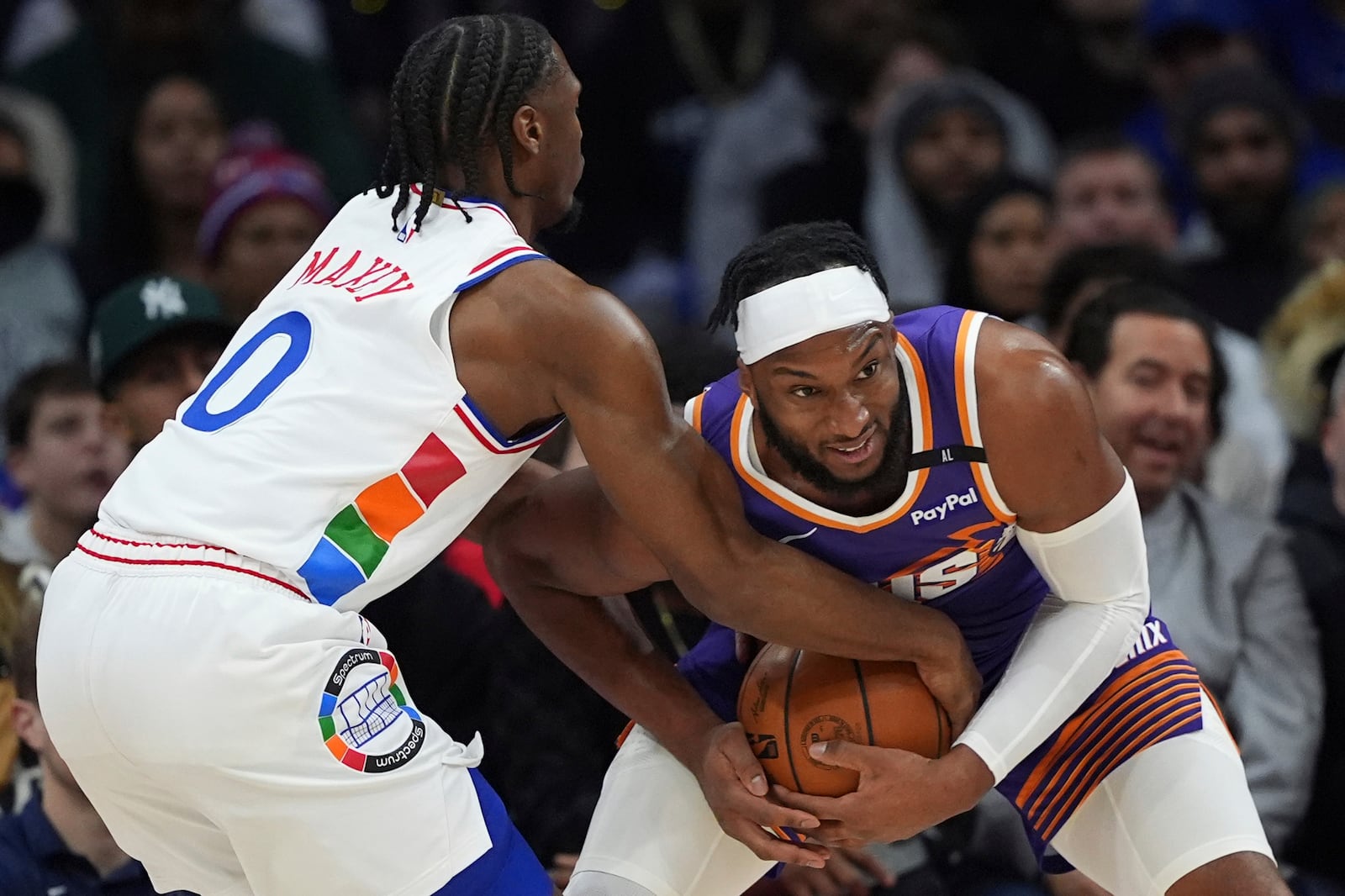 Phoenix Suns' Josh Okogie, right, and Philadelphia 76ers' Tyrese Maxey wrestle for the ball during the first half of an NBA basketball game, Monday, Jan. 6, 2025, in Philadelphia. (AP Photo/Matt Slocum)