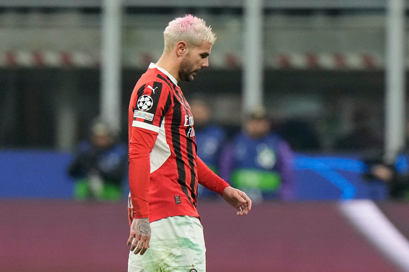 AC Milan's Theo Hernandez leaves the pitch after being sent off by Referee Szymon Marciniak of Poland after his second yellow card during Champions League, playoff second leg soccer match between AC Milan and Feyenoord, at the San Siro stadium in Milan, Italy, Tuesday, Feb.18, 2025. (AP Photo/Luca Bruno)