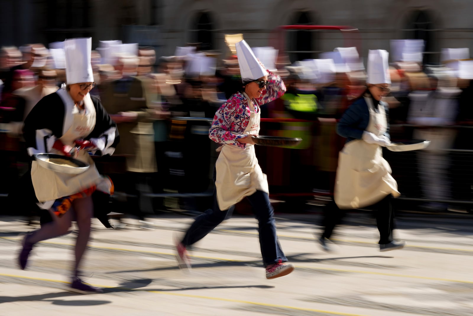 Runners compete during a traditional pancake race by livery companies at the Guildhall in London, Tuesday, March 4, 2025.(AP Photo/Frank Augstein)