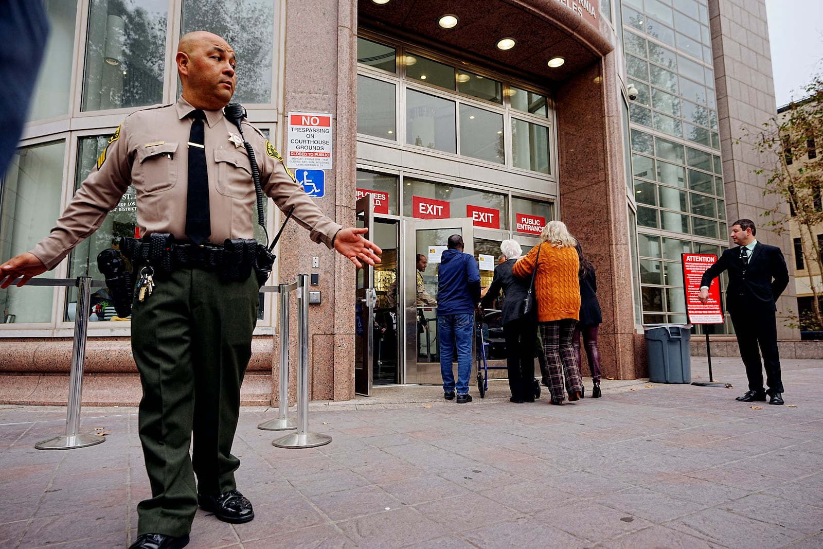 A Los Angeles County sheriff's deputy maintains a perimeter around the Van Nuys courthouse for the hearing for Erik and Lyle Menendez in Los Angeles, Monday, Nov. 25, 2024. (AP Photo/Damian Dovarganes)