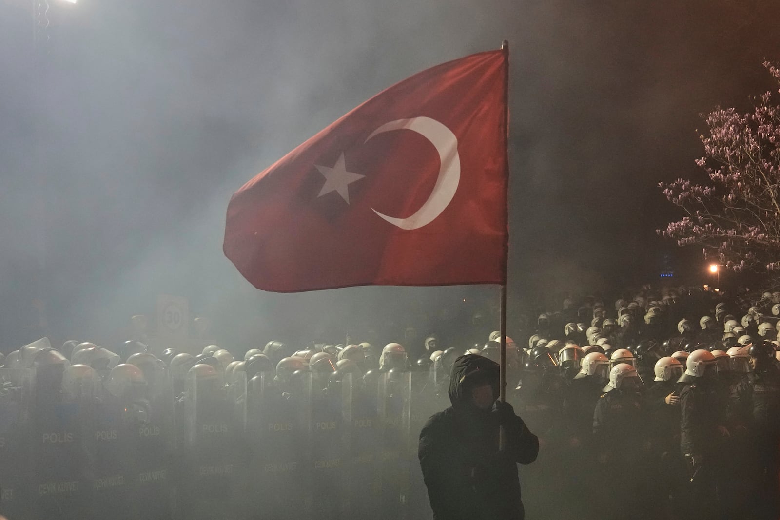 A protester holds up a Turkish flag during a protest against the arrest of Istanbul's Mayor Ekrem Imamoglu, in Istanbul, Turkey, Saturday, March 22, 2025. (AP Photo/Khalil Hamra)