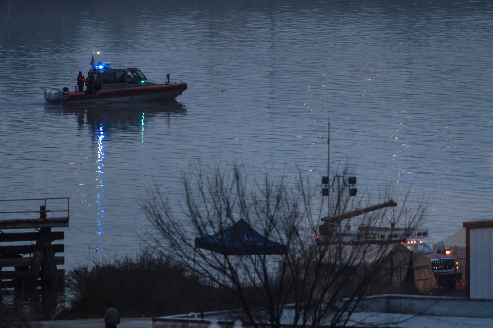 A boat continues to patrol as night falls offshore from emergency vehicles and recovery operations near the mouth of the Anacostia River at the Potomac River near Ronald Reagan Washington National Airport, Friday, Jan. 31, 2025, in Washington. (AP Photo/Carolyn Kaster)