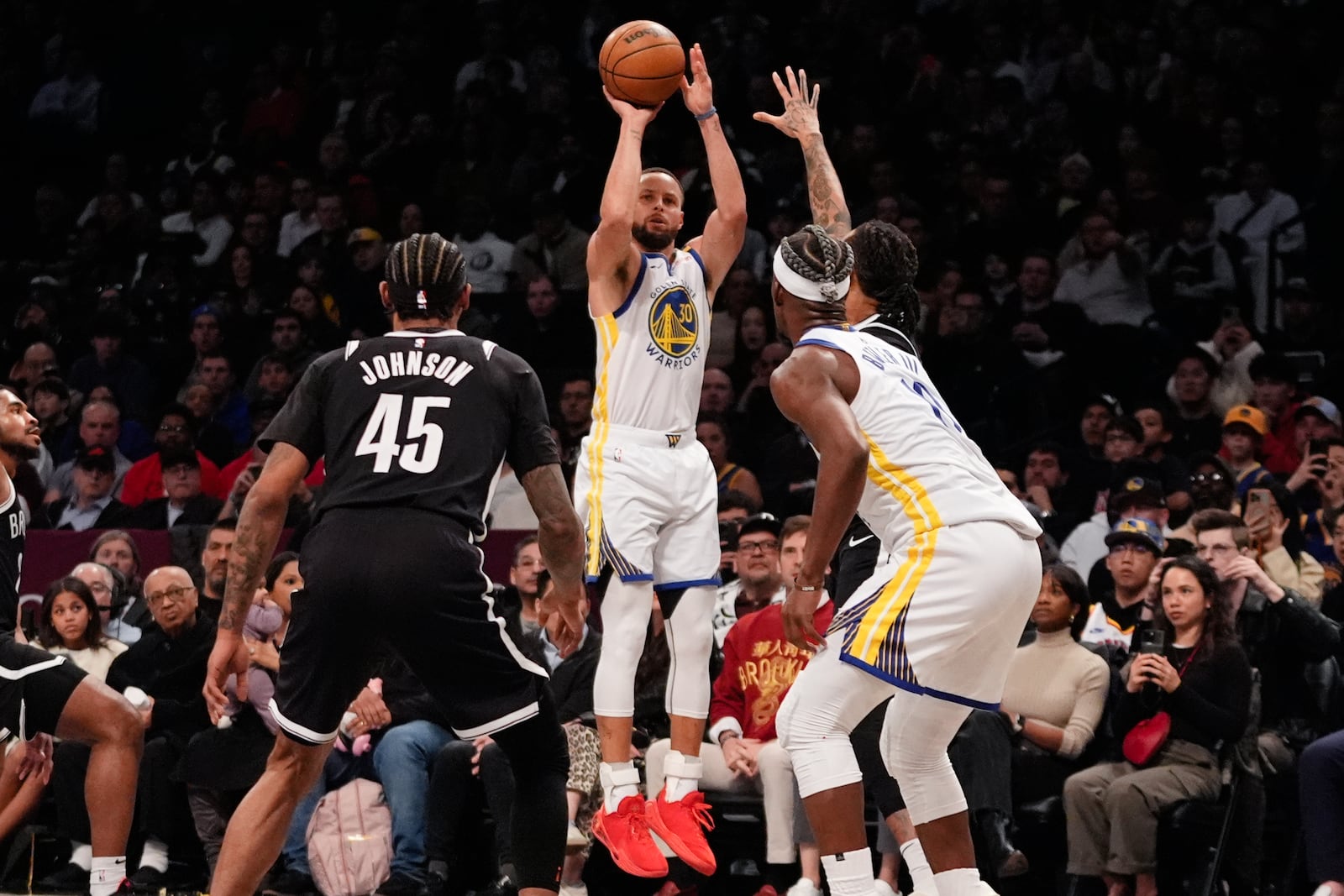 Golden State Warriors' Stephen Curry (30) shoots over Brooklyn Nets' Keon Johnson (45) during the second half of an NBA basketball game Thursday, March 6, 2025, in New York. (AP Photo/Frank Franklin II)