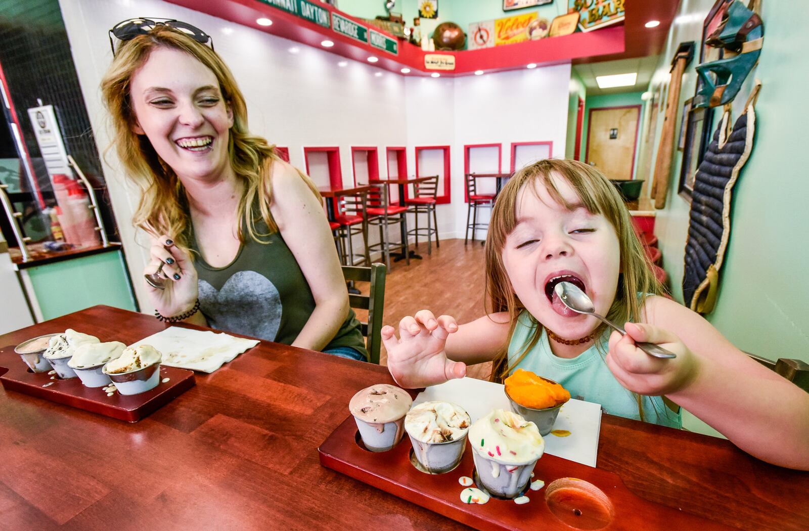 Kelsey Lovelace, left, and Marlee Kaiser, 3, eat ice cream flights at Craft Creamworks Wednesday, July 3 on Dudley Drive in West Chester Township. NICK GRAHAM/STAFF