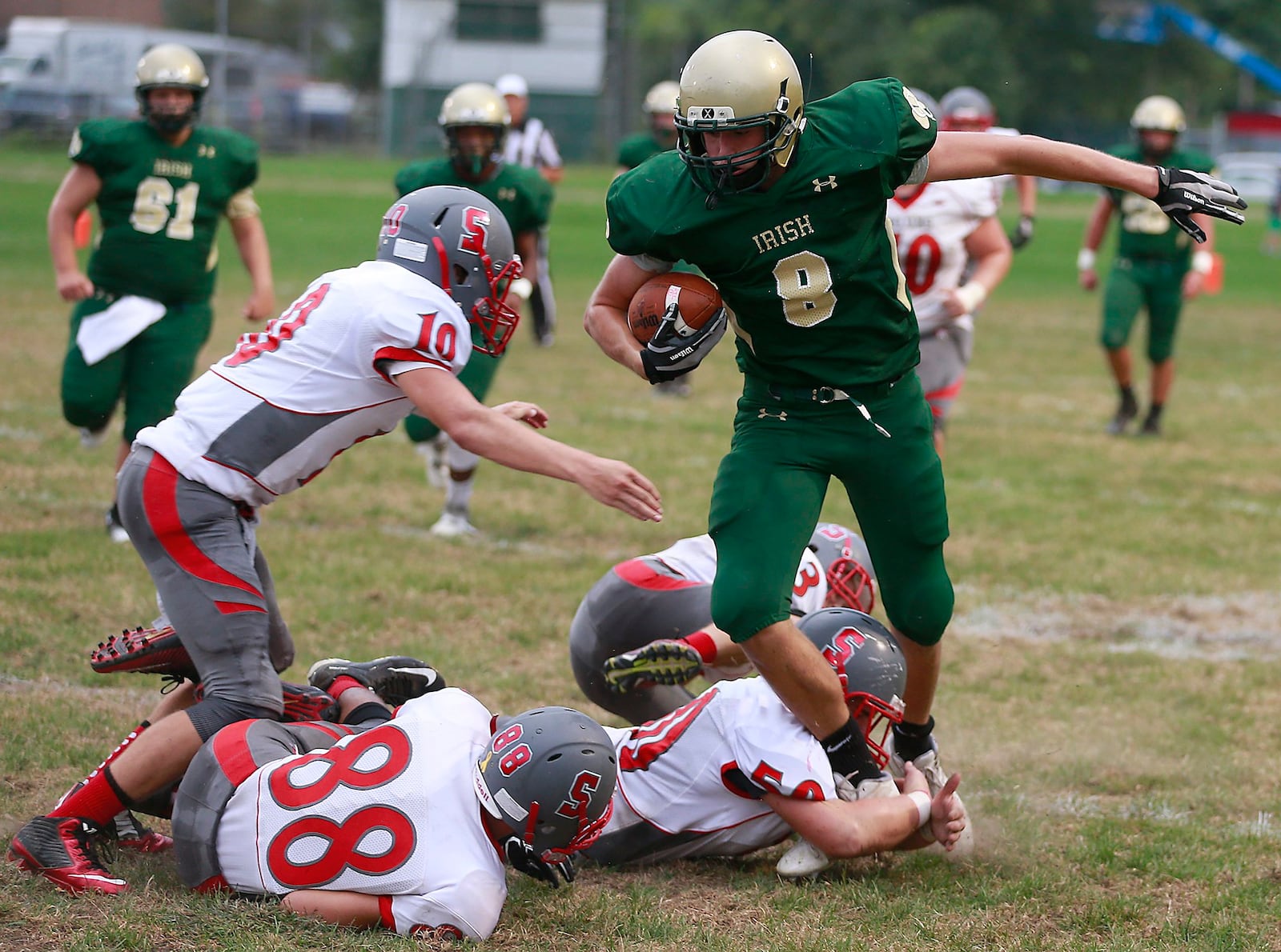 Catholic Central’s Cossy Catanzaro refuses to go down as Southeastern’s Hayden Toops, Joe Sulfridge and Hayden McKee try to tackle him during Friday’s game. Bill Lackey/Staff