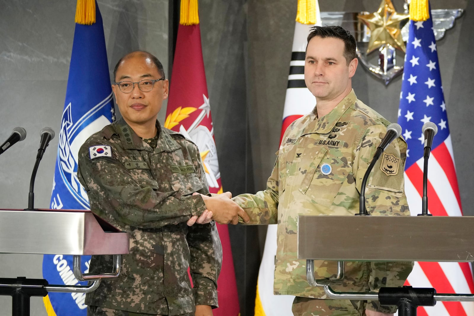 Lee Sung Joon, left, public affairs director of South Korea's Joint Chiefs of Staff (JCS), shakes hand with his U.S. Forces Korea counterpart Ryan Donald during a press briefing of the Freedom Shield exercise at the JCS headquarters in Seoul, South Korea, Thursday, March 6, 2025. (AP Photo/Ahn Young-joon)