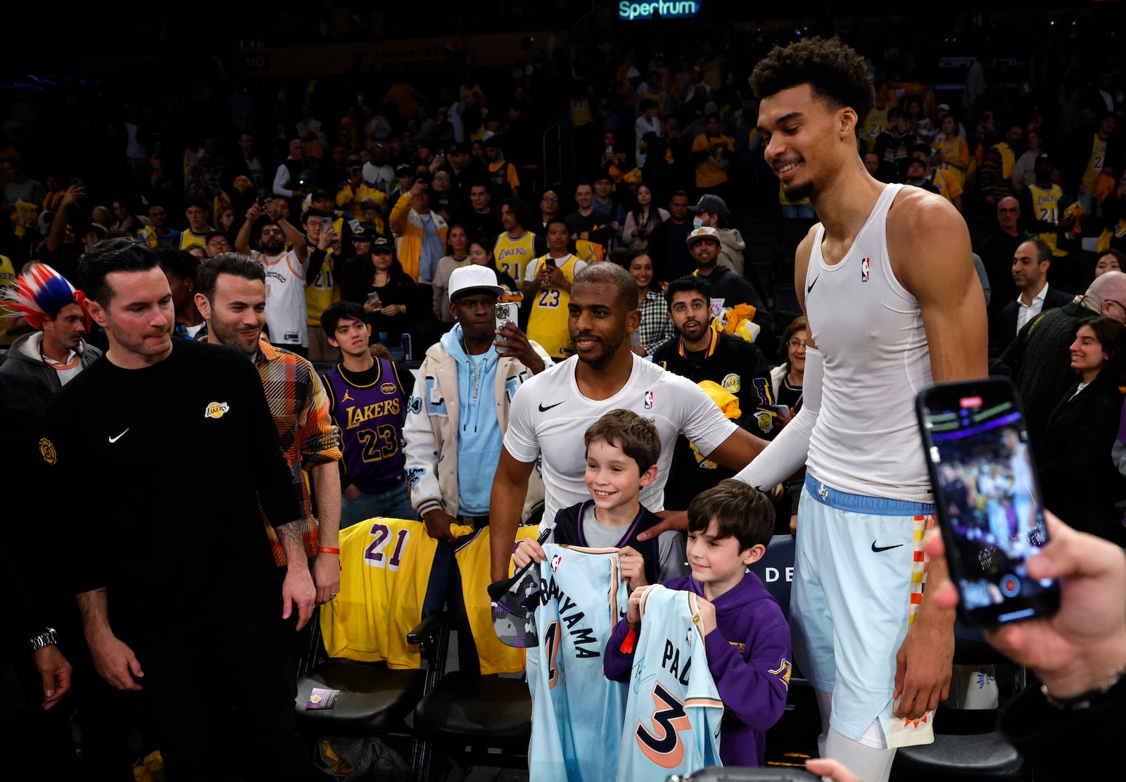 San Antonio Spurs center Victor Wembanyama and guard Chris Paul pose after autographing their jersey with Kai and Knox, children of Los Angeles Lakers head coach JJ Redick after an NBA basketball game Monday, Jan. 13, 2025, in Los Angeles. (AP Photo/Kevork Djansezian)