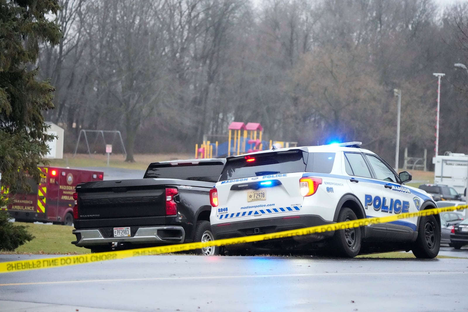 Emergency vehicles are parked outside the Abundant Life Christian School in Madison, Wis., where multiple injuries were reported following a shooting, Monday, Dec. 16, 2024. (AP Photo/Morry Gash)