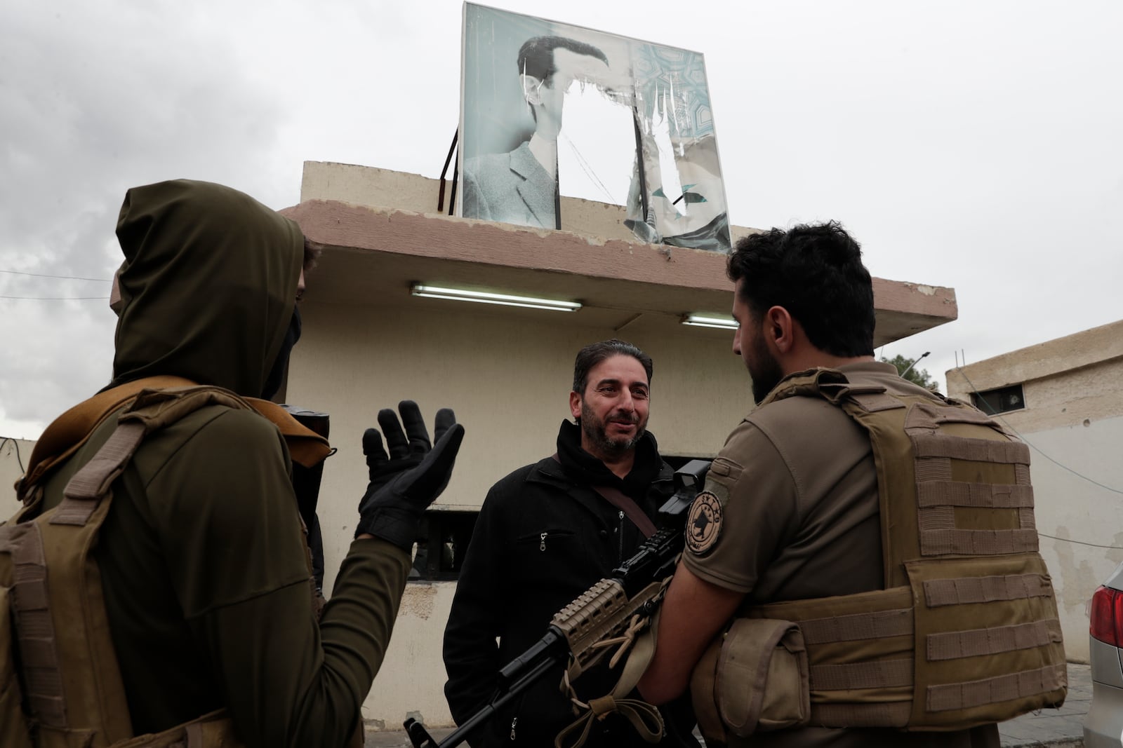 A member of Bashar Assad's army, or a pro-government militia, talks to members of the security forces of the newly formed Syrian government as he takes part in an "identification and reconciliation" process in Damascus, Syria, Monday, Dec. 30, 2024. (AP Photo/Omar Sanadiki)