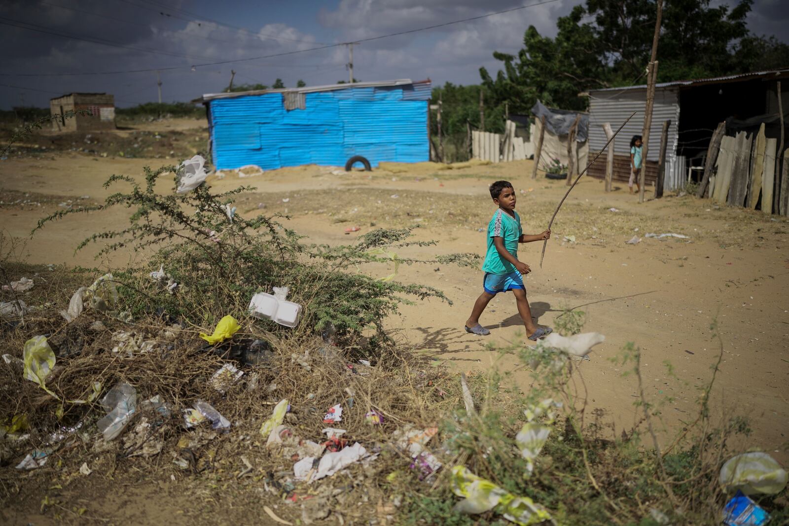 A child plays near trash in the La Voz que Clama neighborhood on the outskirts of Maicao, Colombia, Wednesday, Feb. 5, 2025. (AP Photo/Ivan Valencia)