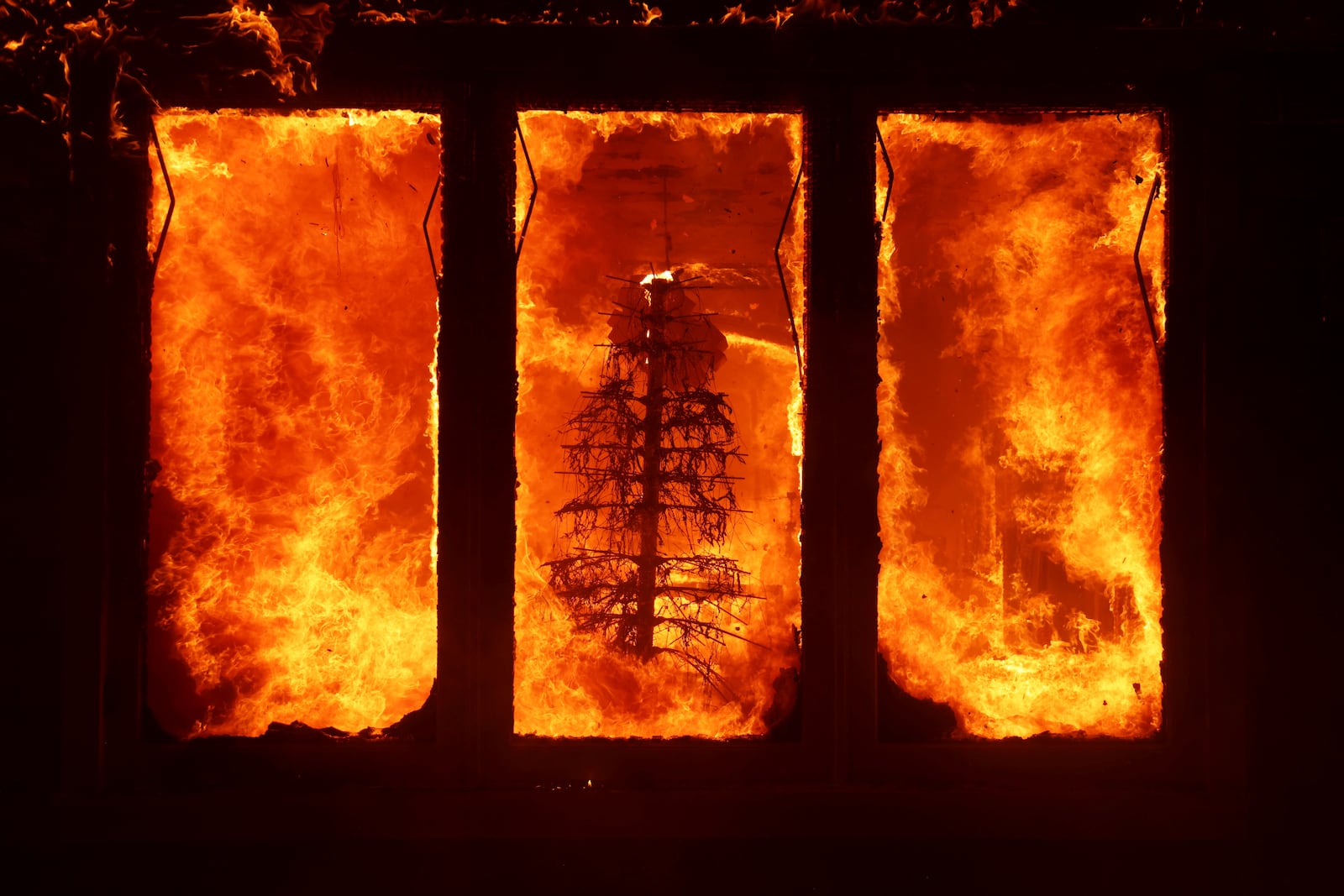 A residence is burned by the Palisades Fire in the Pacific Palisades neighborhood of Los Angeles, Tuesday, Jan. 7, 2025. (AP Photo/Ethan Swope)