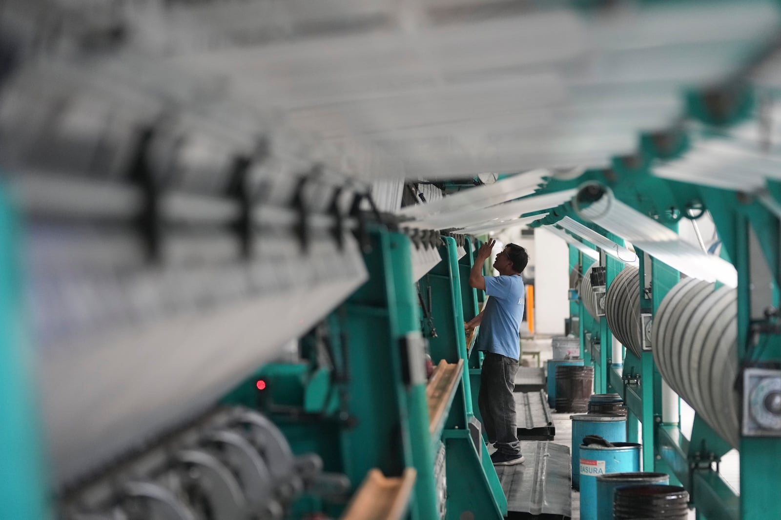 An employee works in a textile factory in Tlaxcala, Mexico, Tuesday, Feb. 4, 2025. (AP Photo/Eduardo Verdugo)