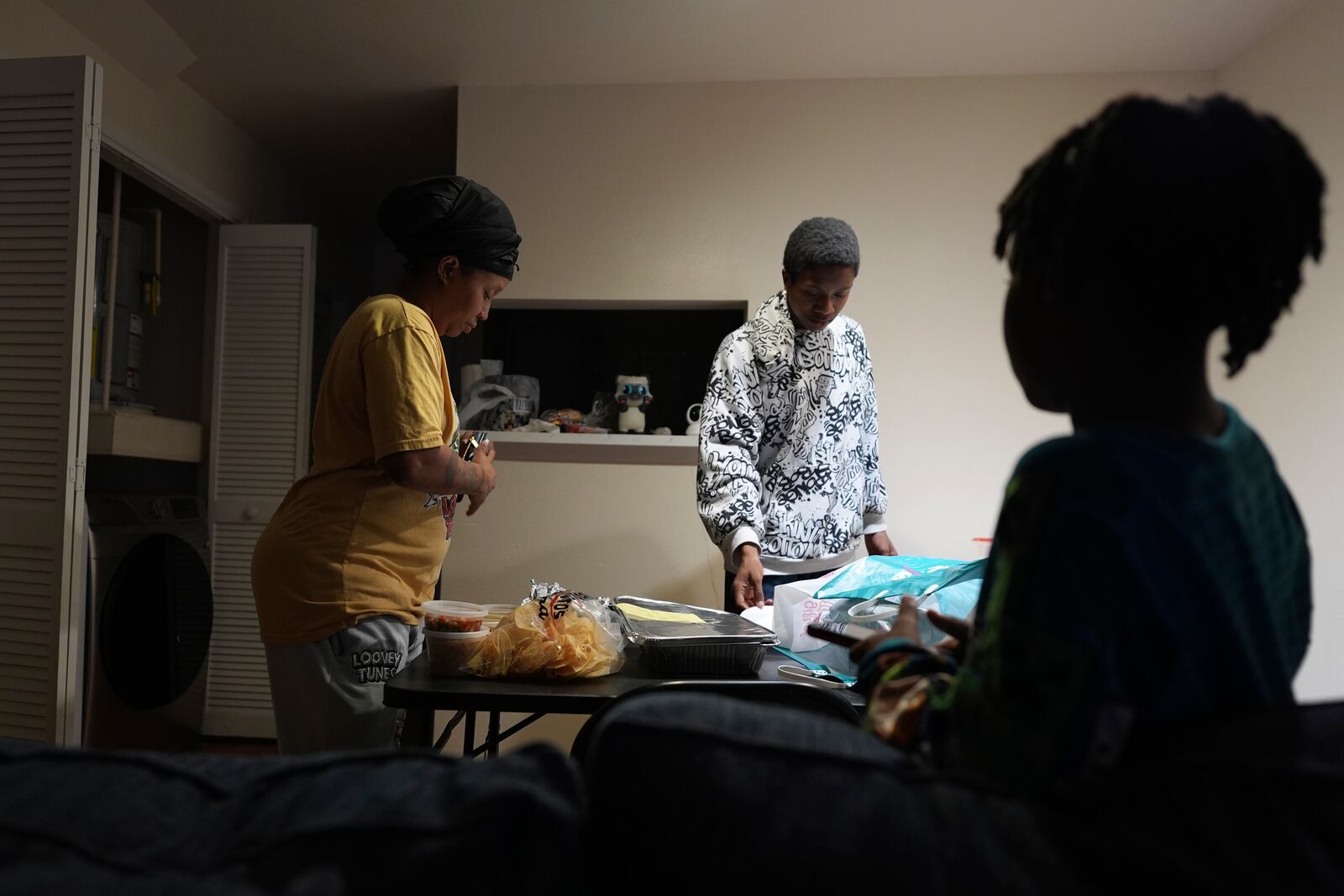 TiAnna Yeldell, with her sons Marq'ue, center, and Ivan, right, sets out dinner at her home, Thursday, Nov. 14, 2024, in Missouri City, Texas. (AP Photo/Eric Gay)