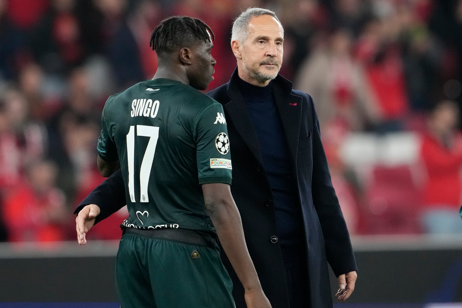 Monaco's head coach Adi Huetter, right, speaks with Monaco's Wilfried Singo at the end of the Champions League playoff second leg soccer match between SL Benfica and AS Monaco at the Luz stadium in Lisbon, Tuesday, Feb. 18, 2025. (AP Photo/Armando Franca)