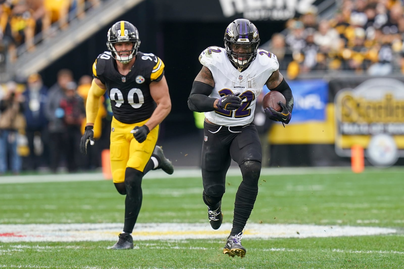 Baltimore Ravens running back Derrick Henry (22) runs with the ball in front of Pittsburgh Steelers linebacker T.J. Watt (90) during the first half of an NFL football game, Sunday, Nov. 17, 2024, in Pittsburgh. (AP Photo/Matt Freed)