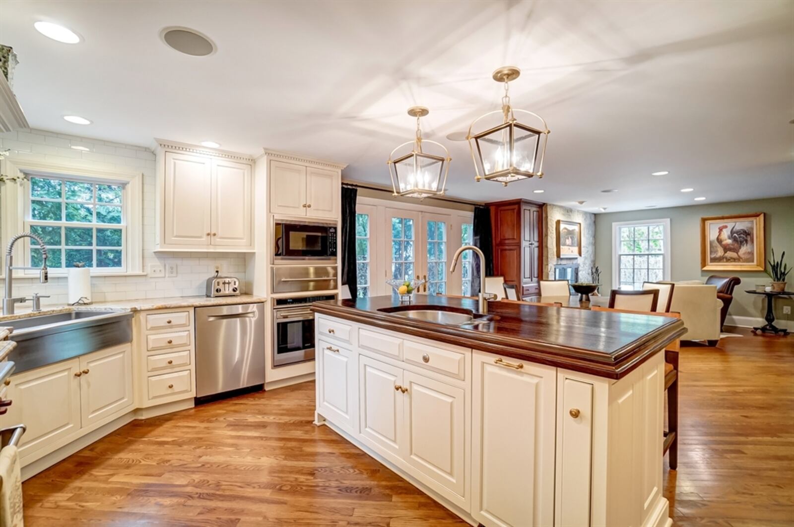 In the kitchen, an island with polished wood counter offers extended counter space for a breakfast bar and preparation sink.