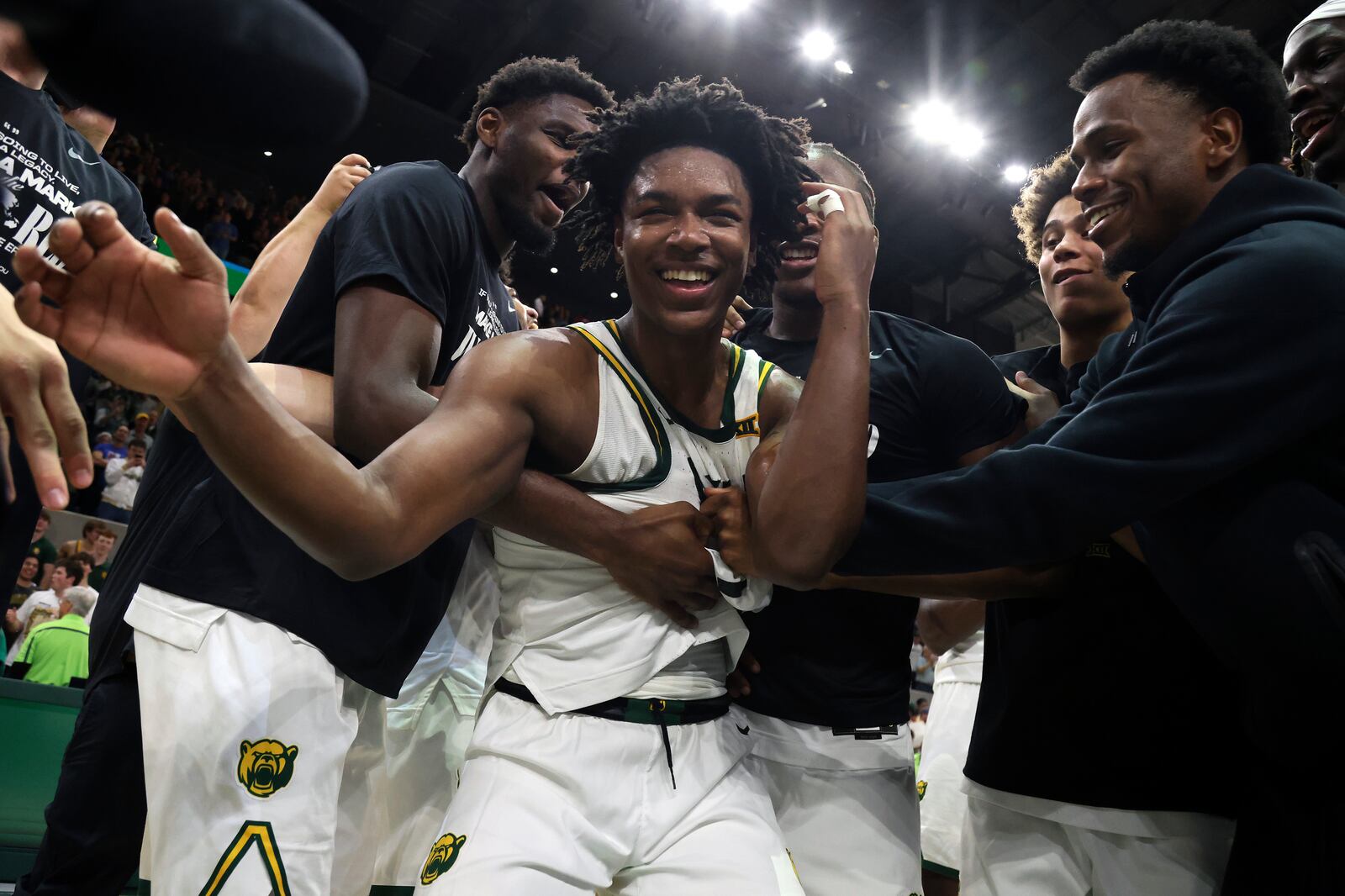 Baylor guard Robert Wright III, center, is mobbed by teammates after they defeated Kansas in an NCAA college basketball game Saturday, Feb. 1, 2025, in Waco, Texas. (AP Photo/Jerry Larson)