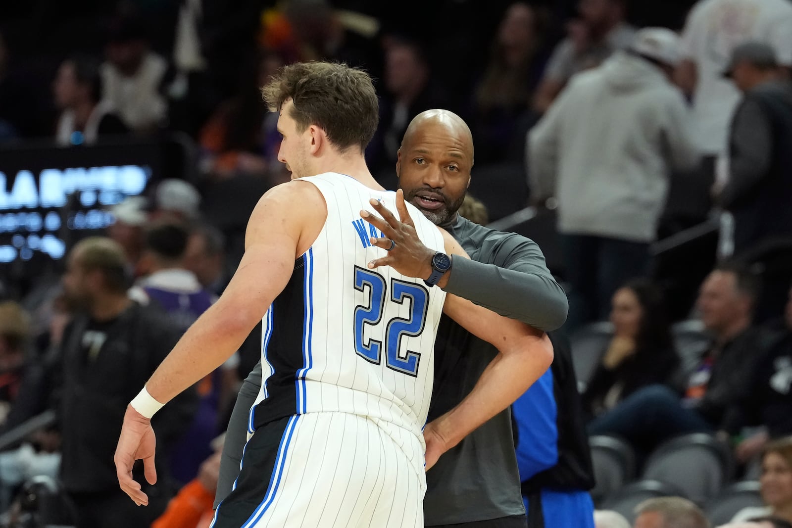 Orlando Magic forward Franz Wagner (22) celebrates with Magic head coach Jamahl Mosley, right, in the closing moments of the second half of an NBA basketball game against the Phoenix Suns, Monday, Nov. 18, 2024, in Phoenix. (AP Photo/Ross D. Franklin)