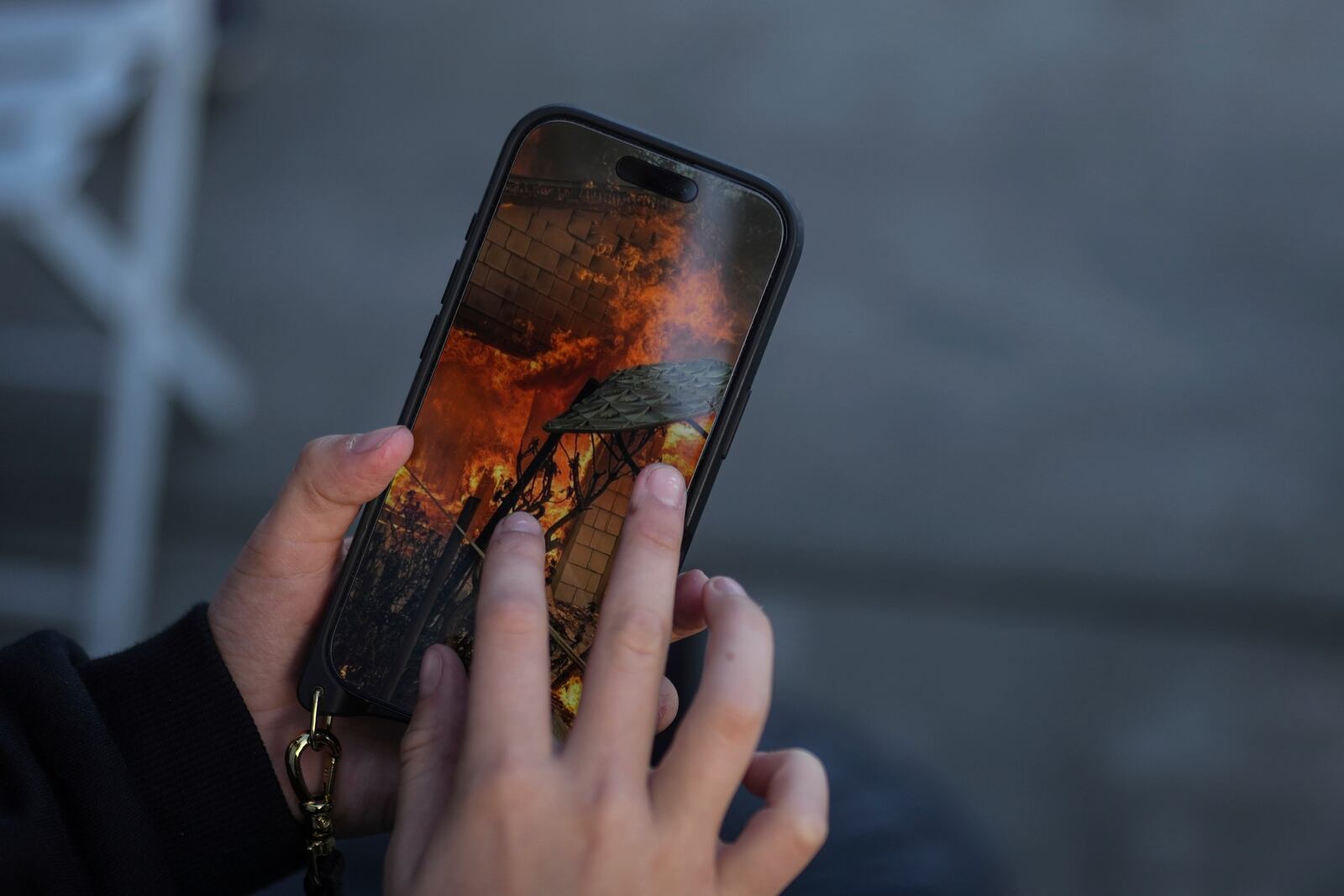 Ceiba Phillips, an 11-year-old Eaton Fire evacuee, looks at a photo on his mother's phone showing the fire destroying his family's in-law suite in Pasadena, Calif., Wednesday, Feb. 5, 2025. (AP Photo/Jae C. Hong)