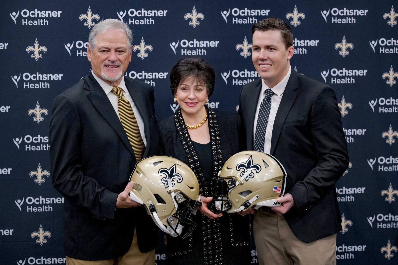 New Orlean Saints new coach Kellen Moore, right, Saints general manager Mickey Loomis, left, and owner Gayle Benson pose during an NFL football press conference in Metairie, La. Thursday, Feb. 13, 2025. (AP Photo/Matthew Hinton)