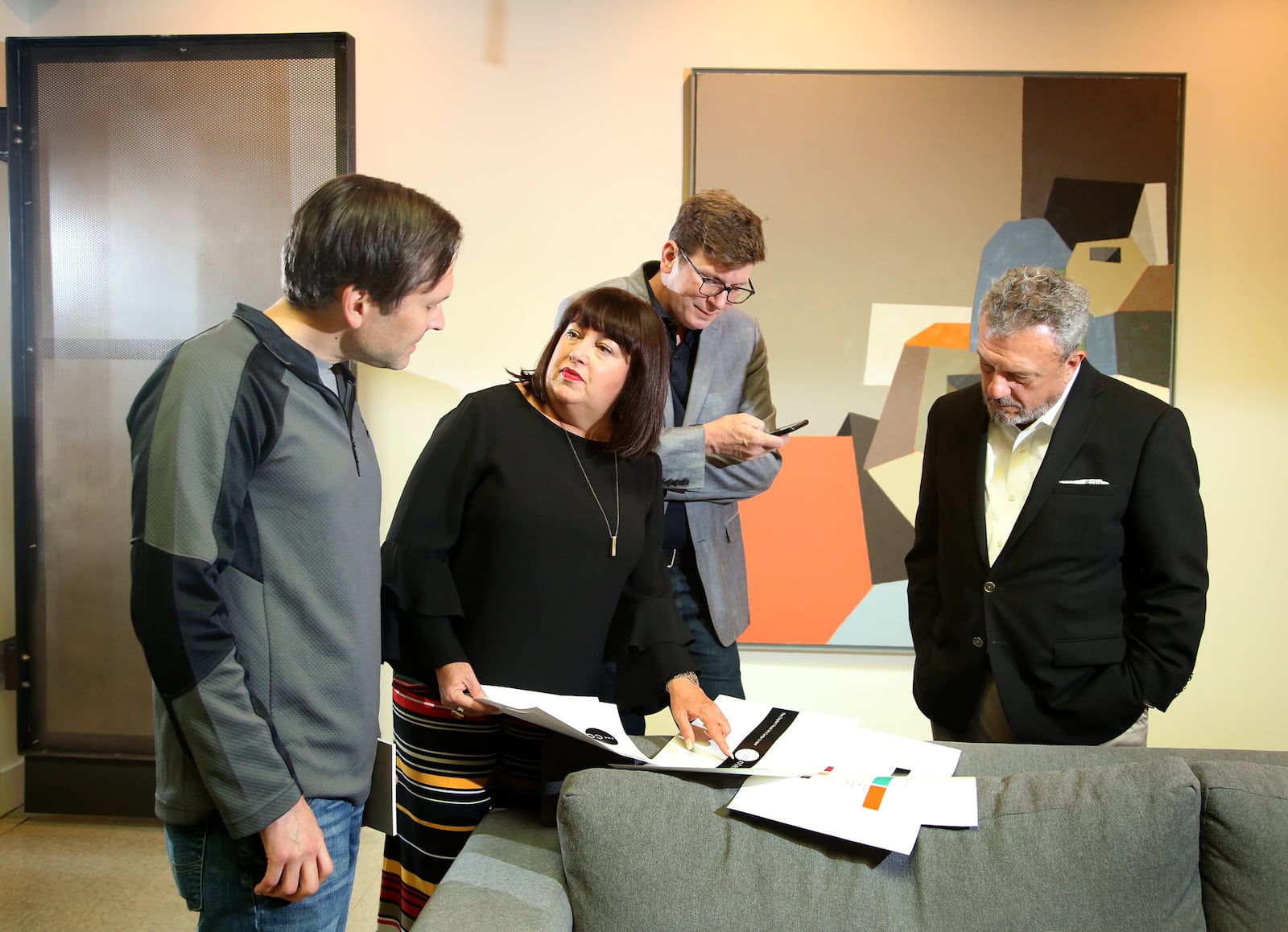 Eva Buttacavoli, executive director of the Dayton Visual Arts Center and Chuck Vella, president of DVAC's board of trustees (far right) are working with Phil Neal (left) and Doug Lunne of LMG, a Dayton marketing firm, to create a new strategy for the Dayton arts organization. LISA POWELL