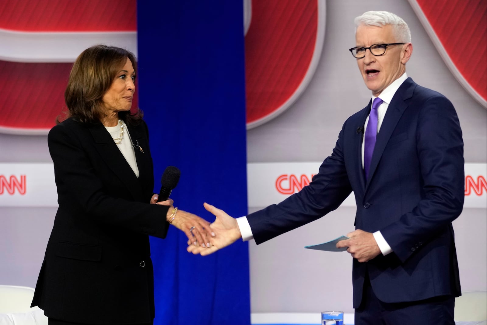 Democratic presidential nominee Vice President Kamala Harris shakes hands with moderator Anderson Cooper at a CNN town hall in Aston, Pa., Wednesday, Oct. 23, 2024. (AP Photo/Matt Rourke)