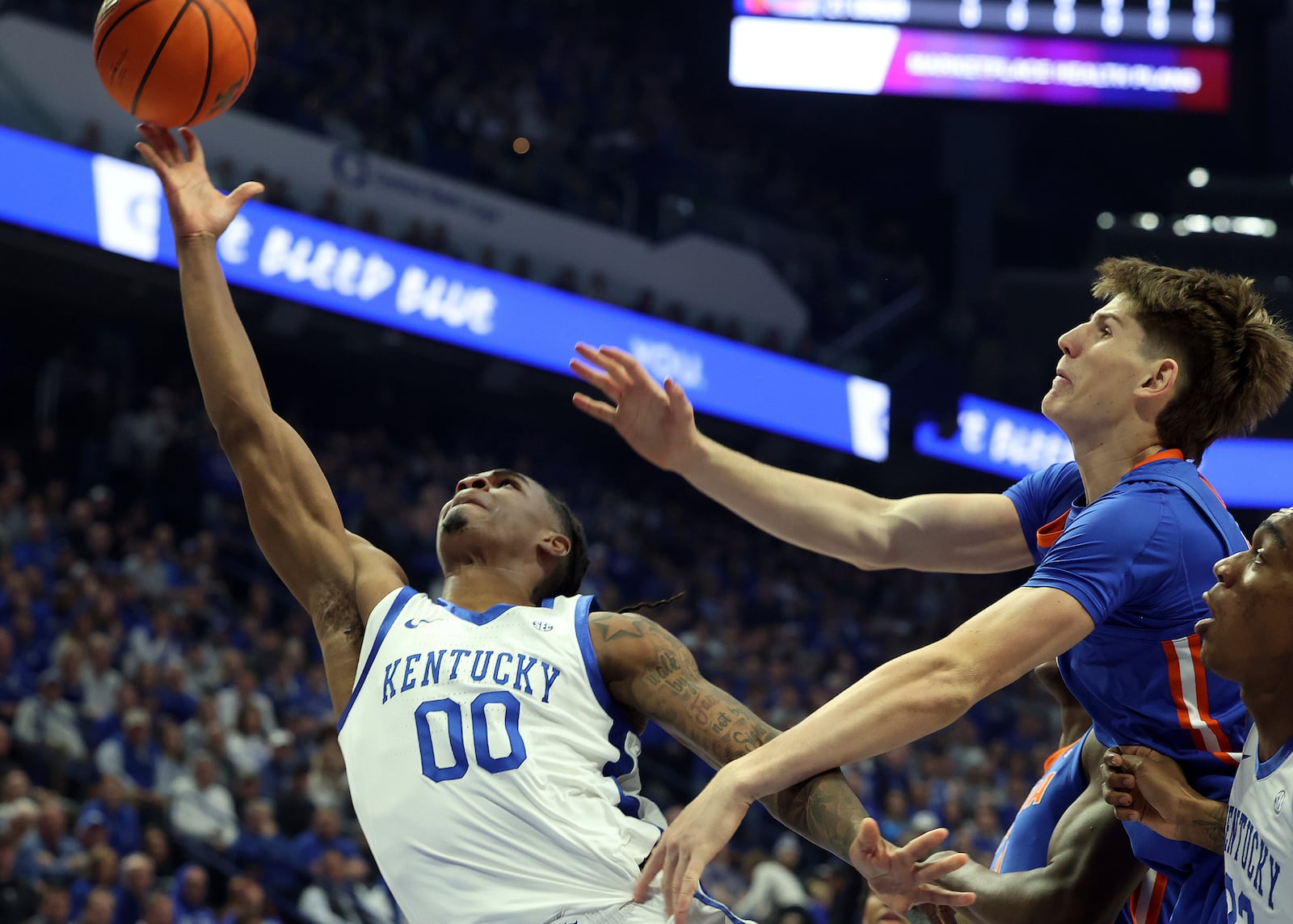 Kentucky's Otega Oweh (00) throws up a shot near Florida's Alex Condon, right, during the first half of an NCAA college basketball game in Lexington, Ky., Saturday, Jan. 4, 2025. (AP Photo/James Crisp)