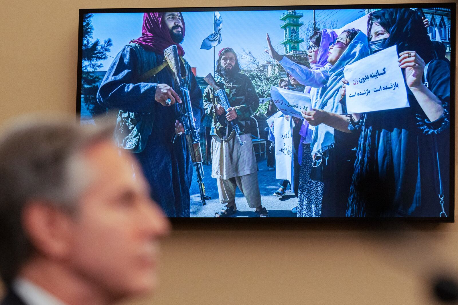 Secretary of State Antony Blinken speaks as a photograph from Afghanistan is seen on a television screen during a House Committee on Foreign Affairs hearing on the US withdrawal from Afghanistan, Wednesday, Dec. 11, 2024, on Capitol Hill in Washington. (AP Photo/Jacquelyn Martin)