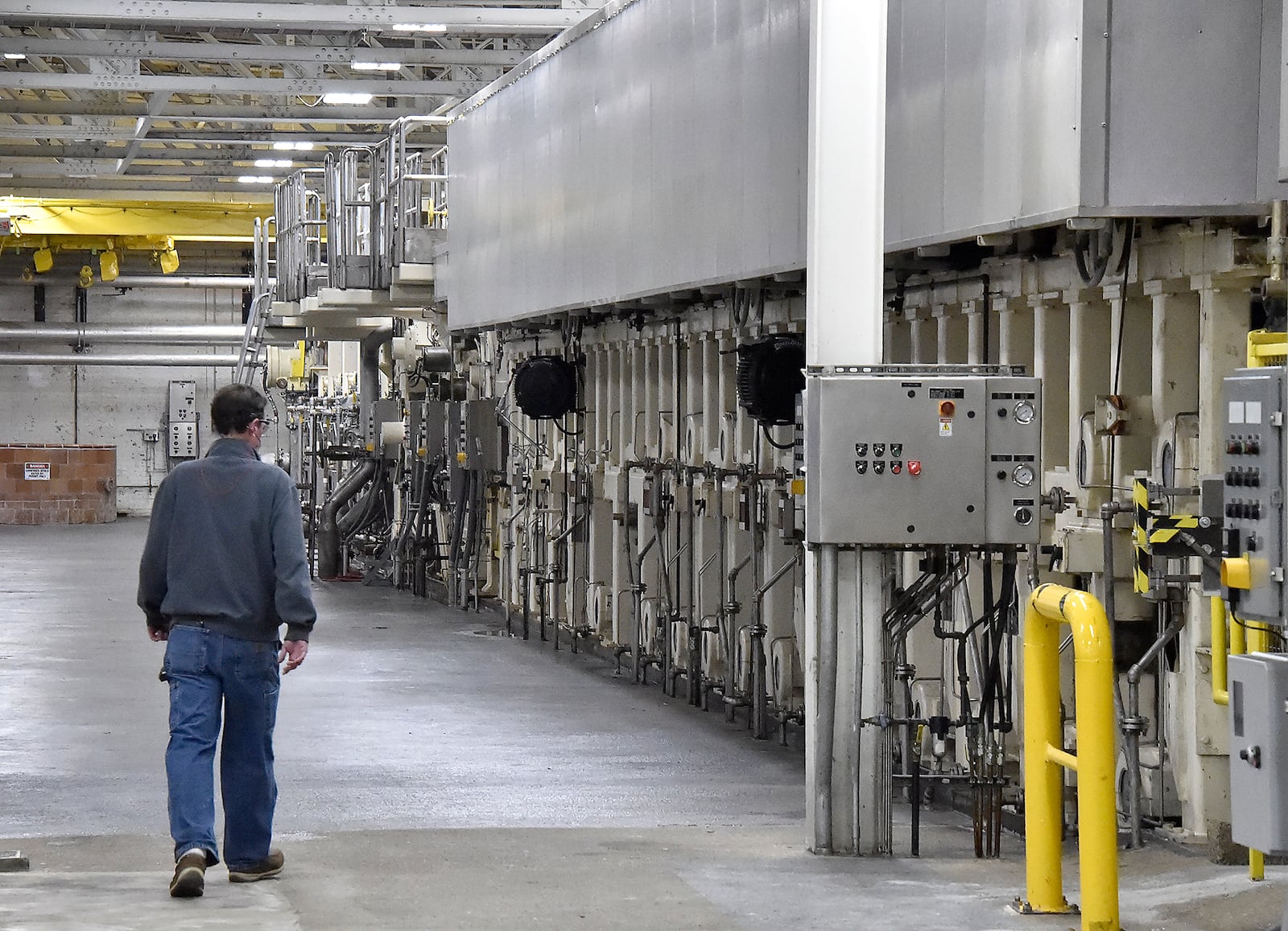 A Weidmann employee walks along the giant paper machine in the company’s Urbana factory. The company is one of several that are participating in the Champaign Economic Partnership’s new website for job-seekers. Bill Lackey/Staff